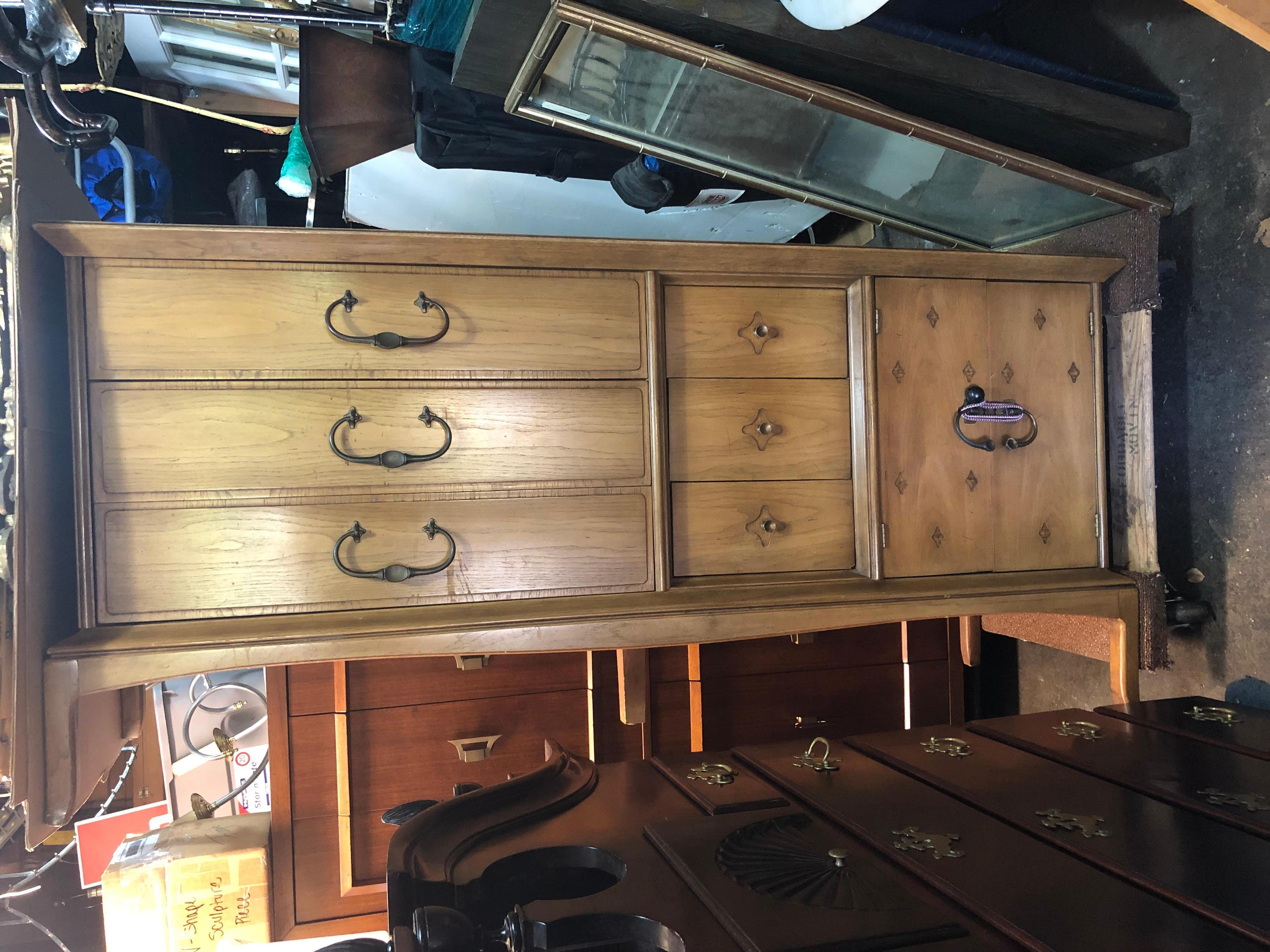 Long midcentury dresser or credenza in original condition. Has three long drawers, three short drawers and three concealed drawers behind doors. Solid, quality American made piece with no structural issues. This is in original condition with surface