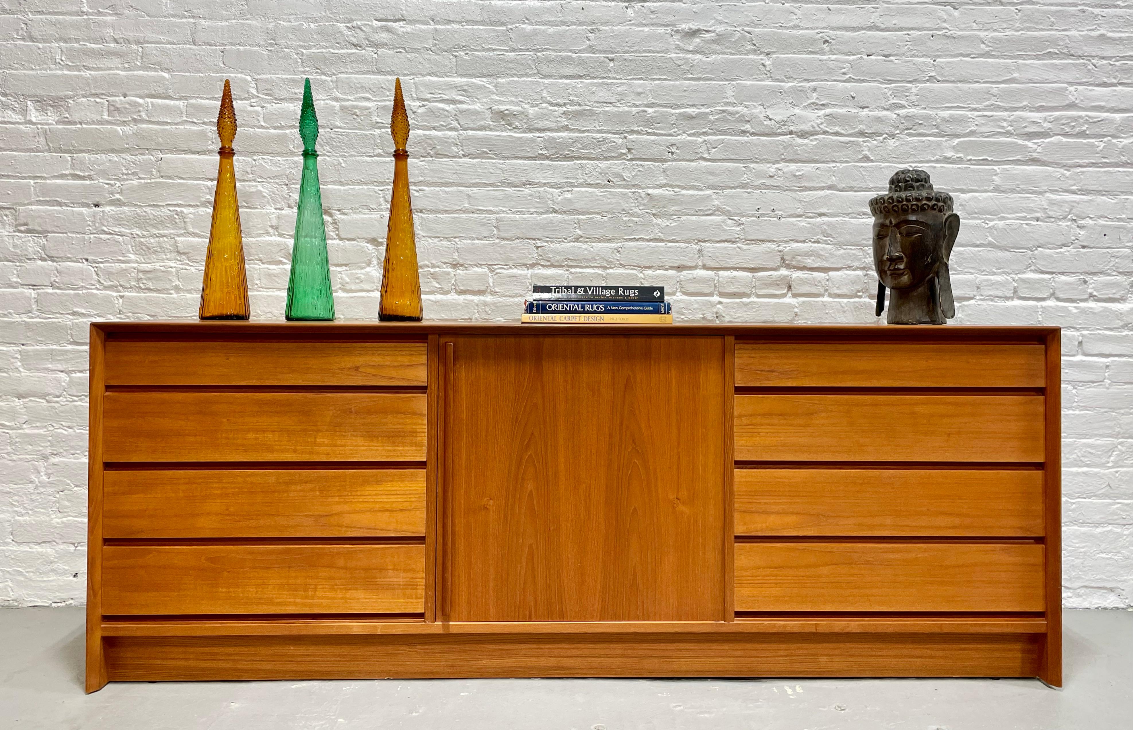 Spectacular Mid Century Modern Teak Long Dresser / Credenza by Falster Mobelfabrik, Made in Denmark, c. 1960’s. Crafted of old-growth teak and boasting 13 drawers for all your storage needs. The left and right sides features four drawers each with