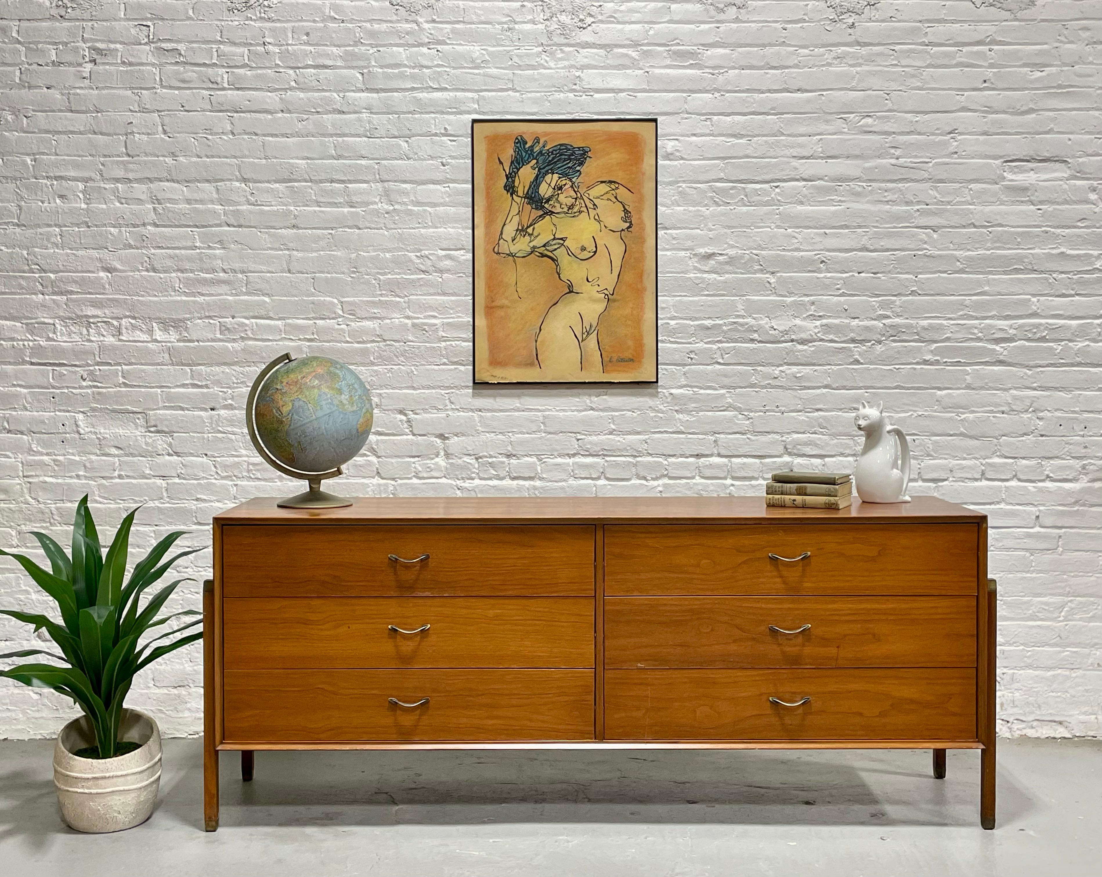 Comò lungo in noce del Mid Century Modern nello stile di Dunbar, anni '60 circa.  Questa lunga credenza è messa in risalto dalle gambe fissate lungo i lati, che le conferiscono un aspetto fluttuante. Le gambe sono sormontate e sormontate da CAP in
