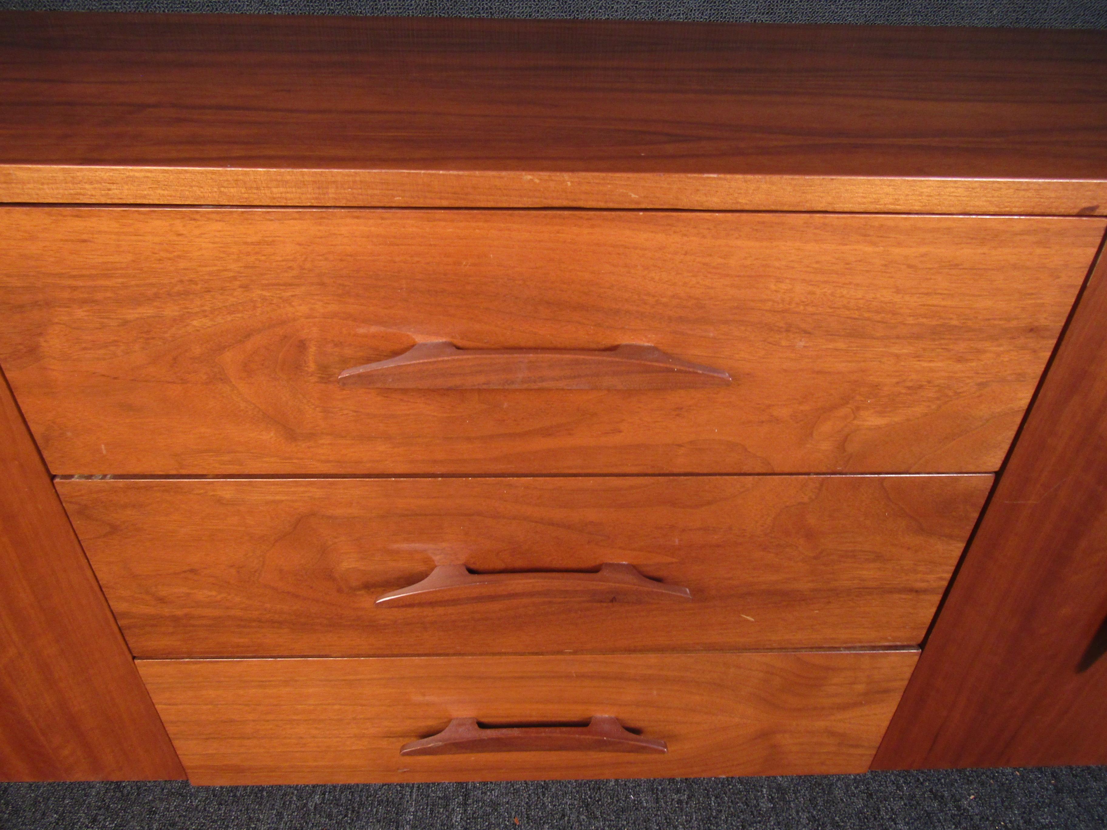 A Mid-Century Modern server that showcases a rich walnut woodgrain and nine spacious drawers. With a stylish design and quality that is built to last, this server will be a beautiful addition to any home for years to come. Please confirm item