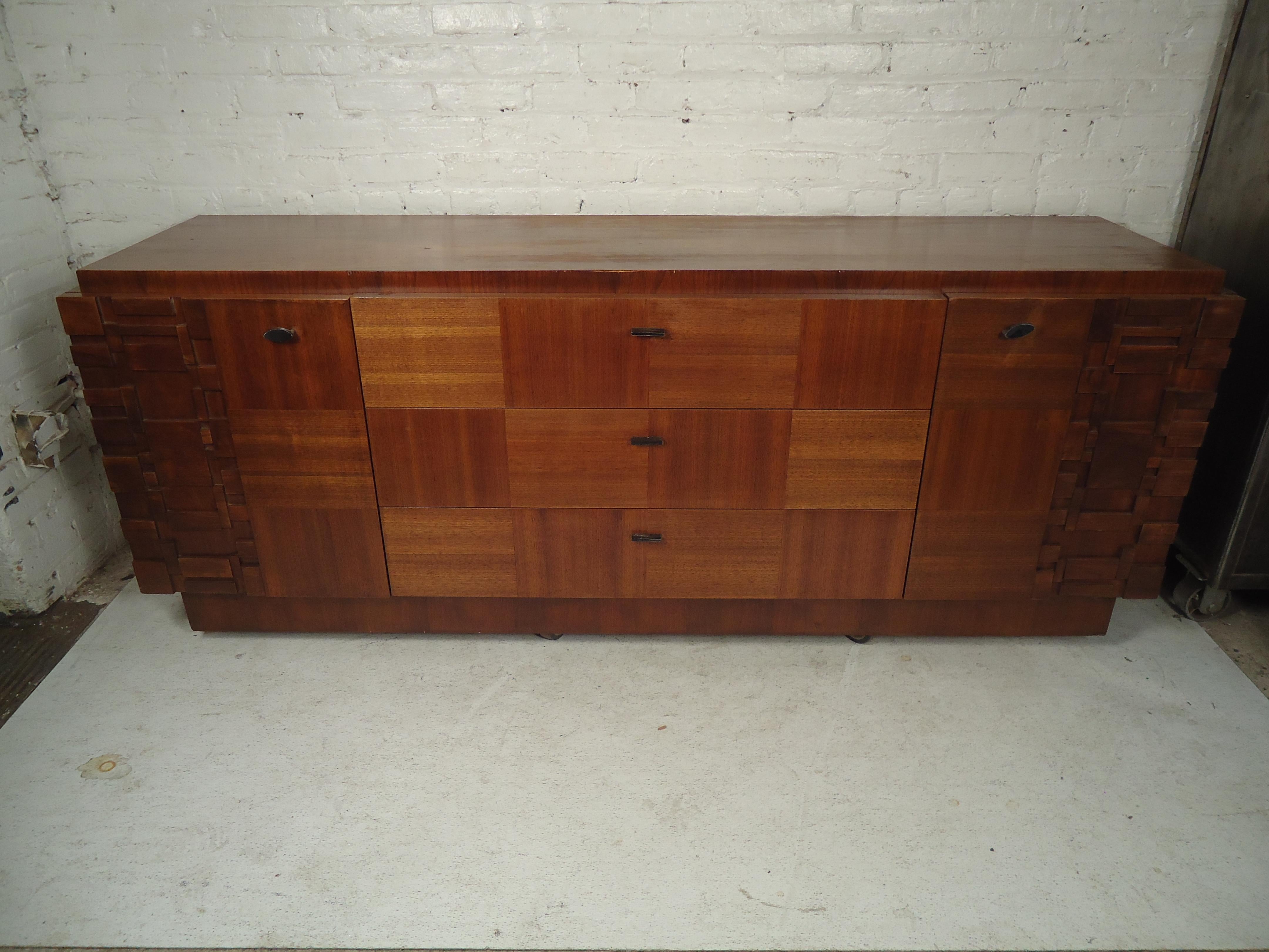 Fantastic mid-century vintage credenza from leading Canadian modern manufacturers Tobago Furniture. Featuring a fantastic carved brutalist motif with an accompanying patchwork veneer, the piece pays homage to the classic designs of Lane Furniture's
