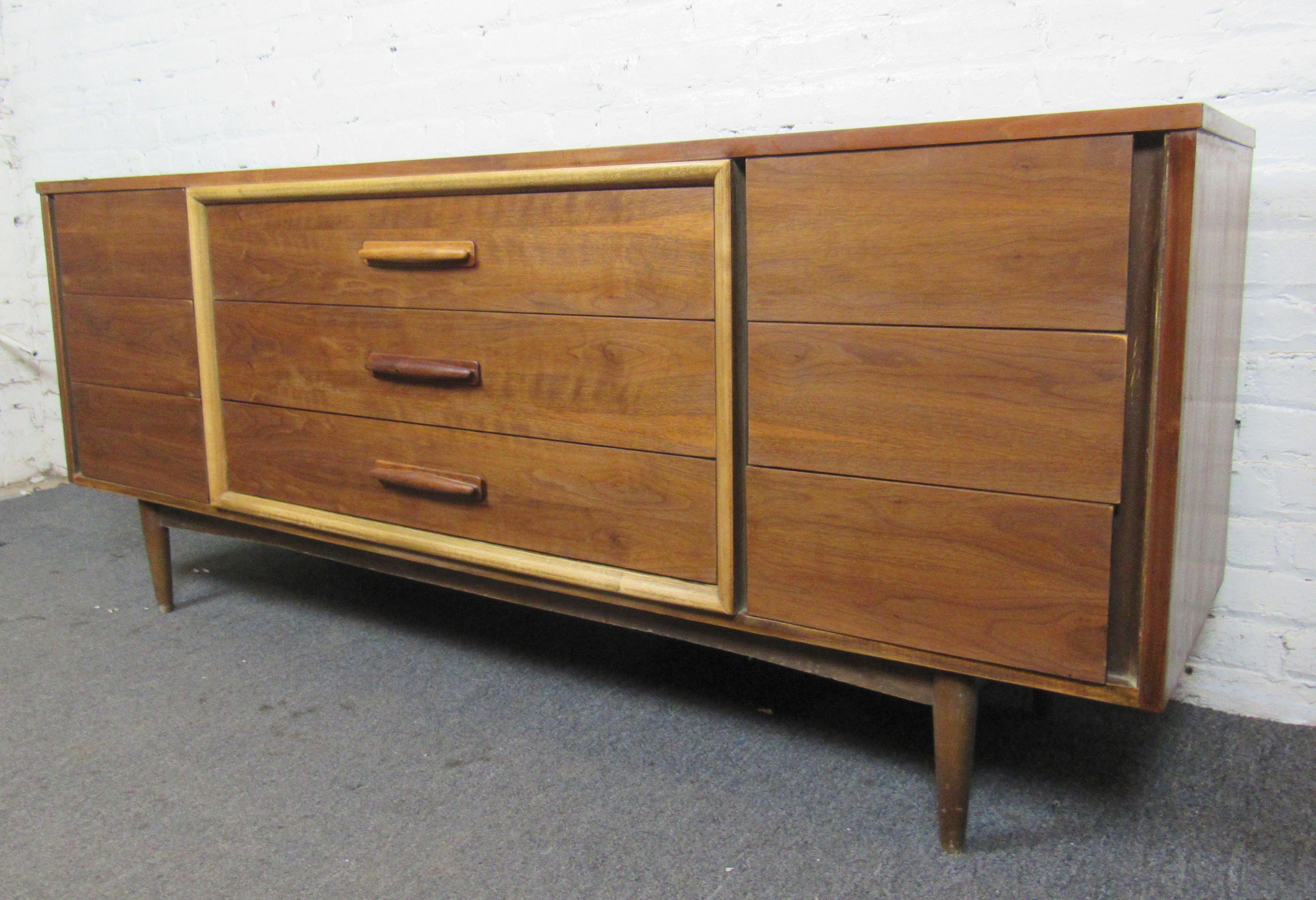 Mid-Century Modern walnut dresser with nine wide drawers. Features wood handles and cone legs.
Location: Brooklyn NY.