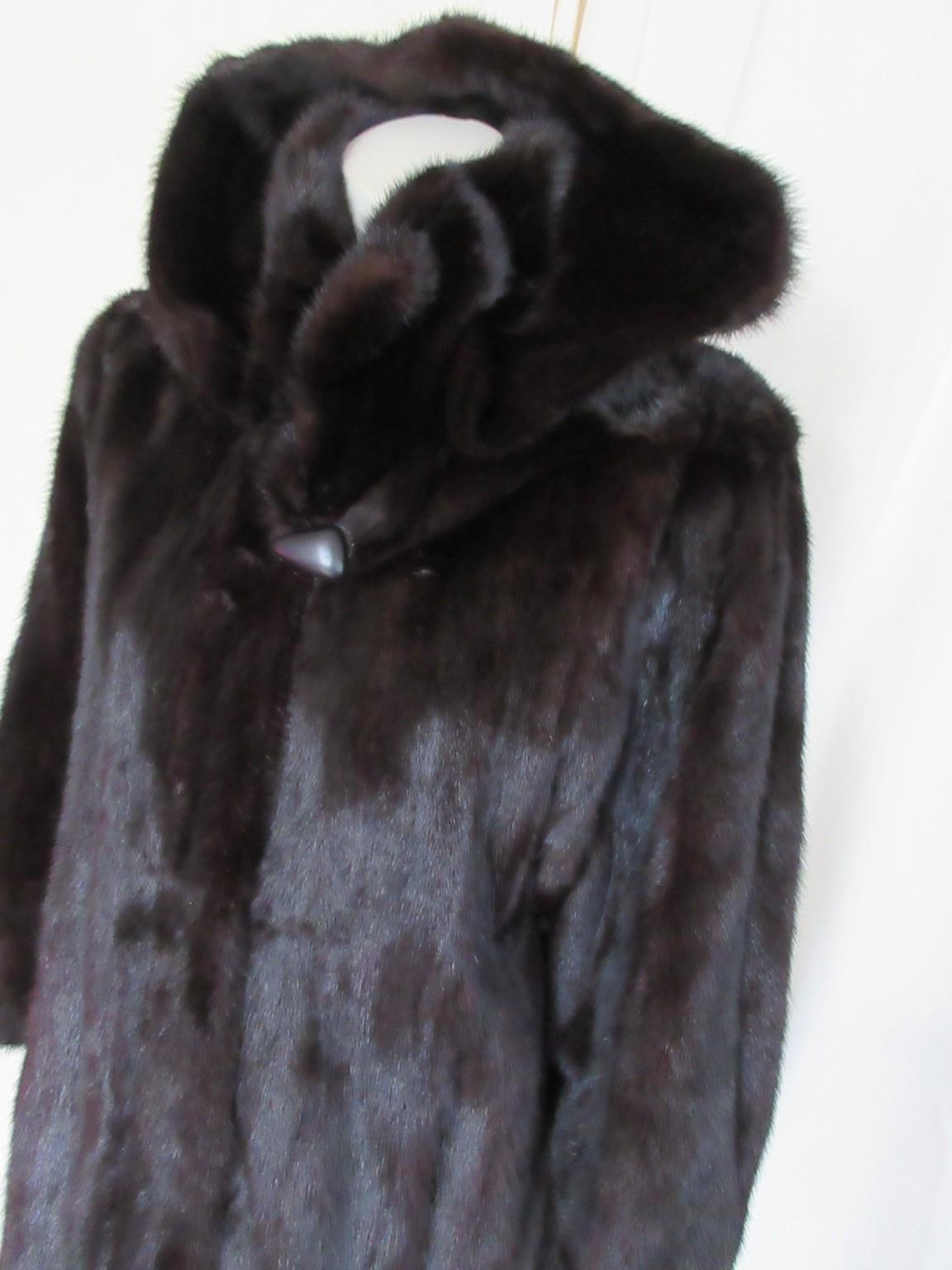 Long mink fur coat with attached hood.
Rare to find

We offer more exclusive lambskin and fur items, view our frontstore.

Details:
With 2 pockets, 4 closing hooks, 1 collar button
Interior of hood is lined
Hood is detachable with clips
Color; dark