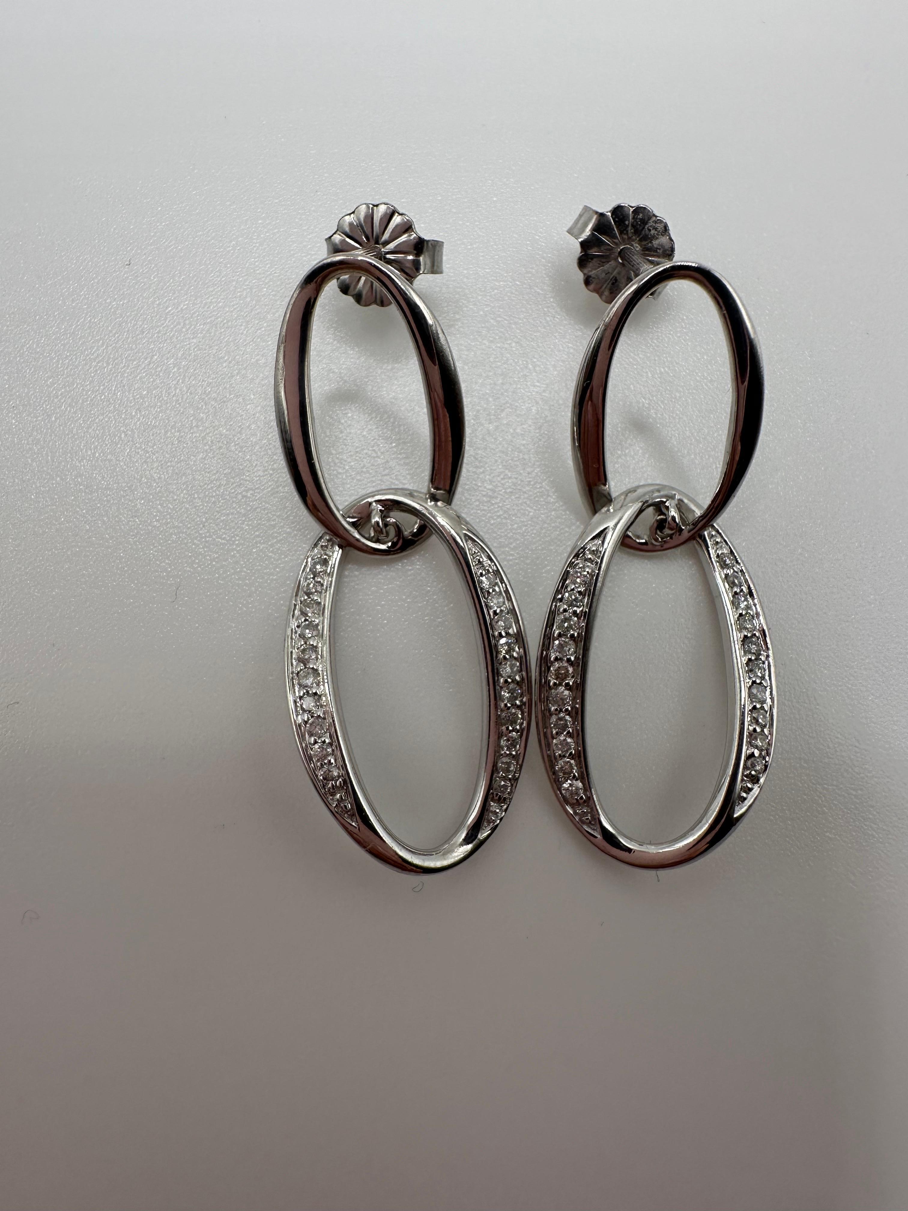 Bellissimo paio di orecchini che starebbero bene con qualsiasi vestito! Orecchini pendenti in oro bianco 14KT con diamanti naturali.

Tipo di metallo: 14KT

Diamante/i naturale/i: 
Colore: F-G
Taglio: Rotondo brillante 
Chiarezza: VS (media)
Carati: