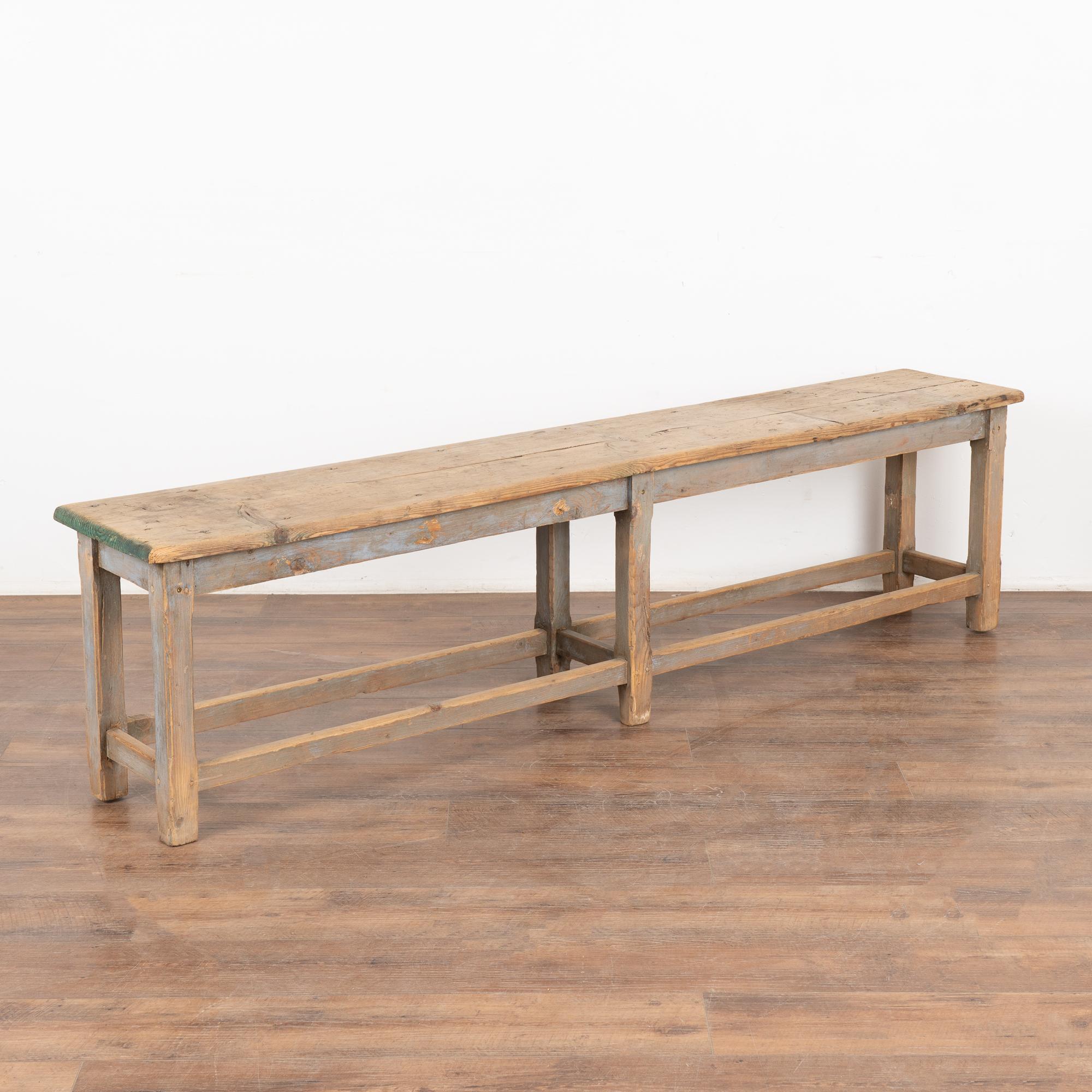 Rustic plank top bench with deep aged patina, see residual blue/gray paint and touches of green.
The top reveals generations of use with nicks, stains, cracks and scuffs which add character to the narrow bench.
Restored, this bench is strong, stable