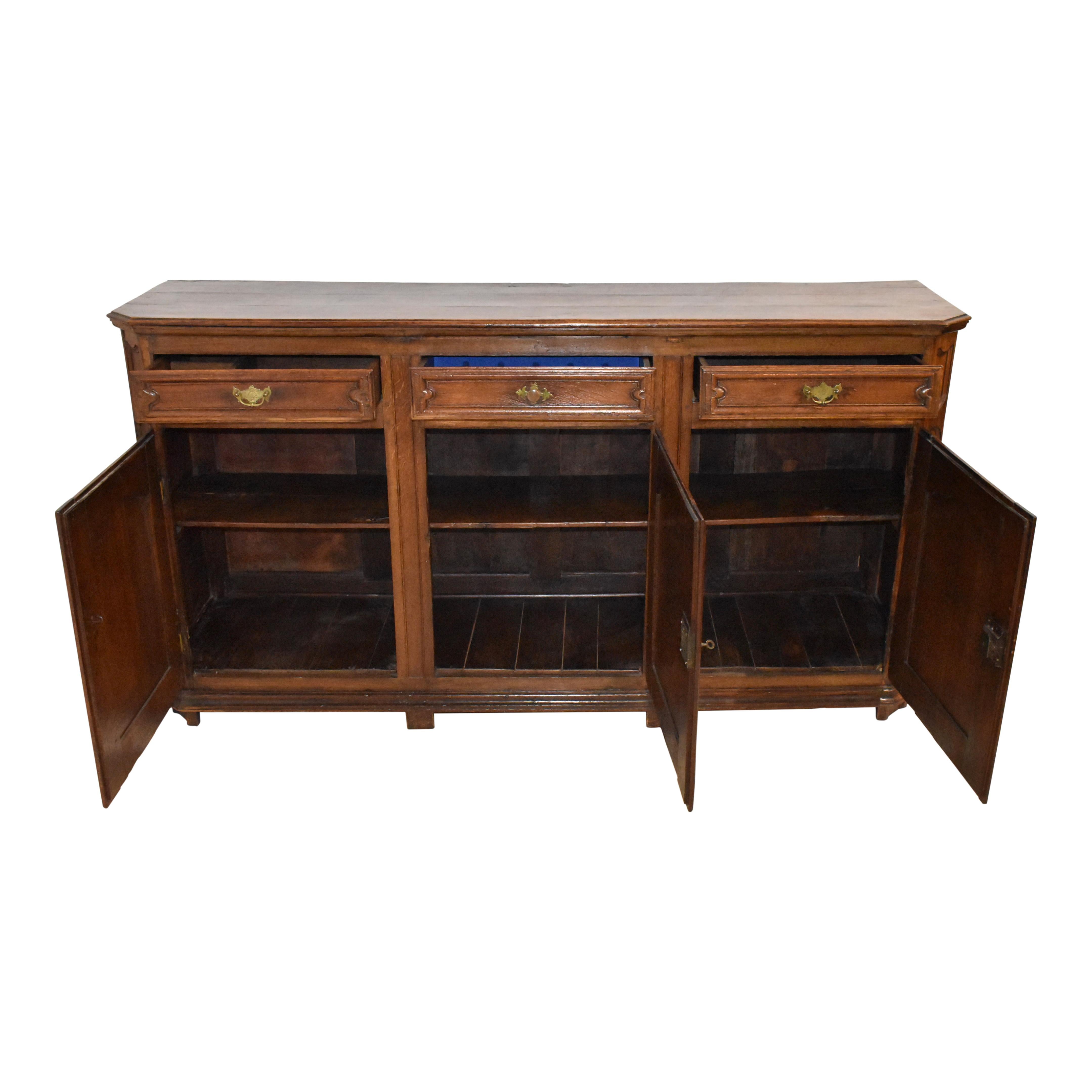 Made of quality European oak and designed with superior craftsmanship, this lengthy sideboard buffet has a footprint of nearly seven feet. Comprised of three drawers over three doors, it has a wealth of storage. The sideboard features a beveled top,