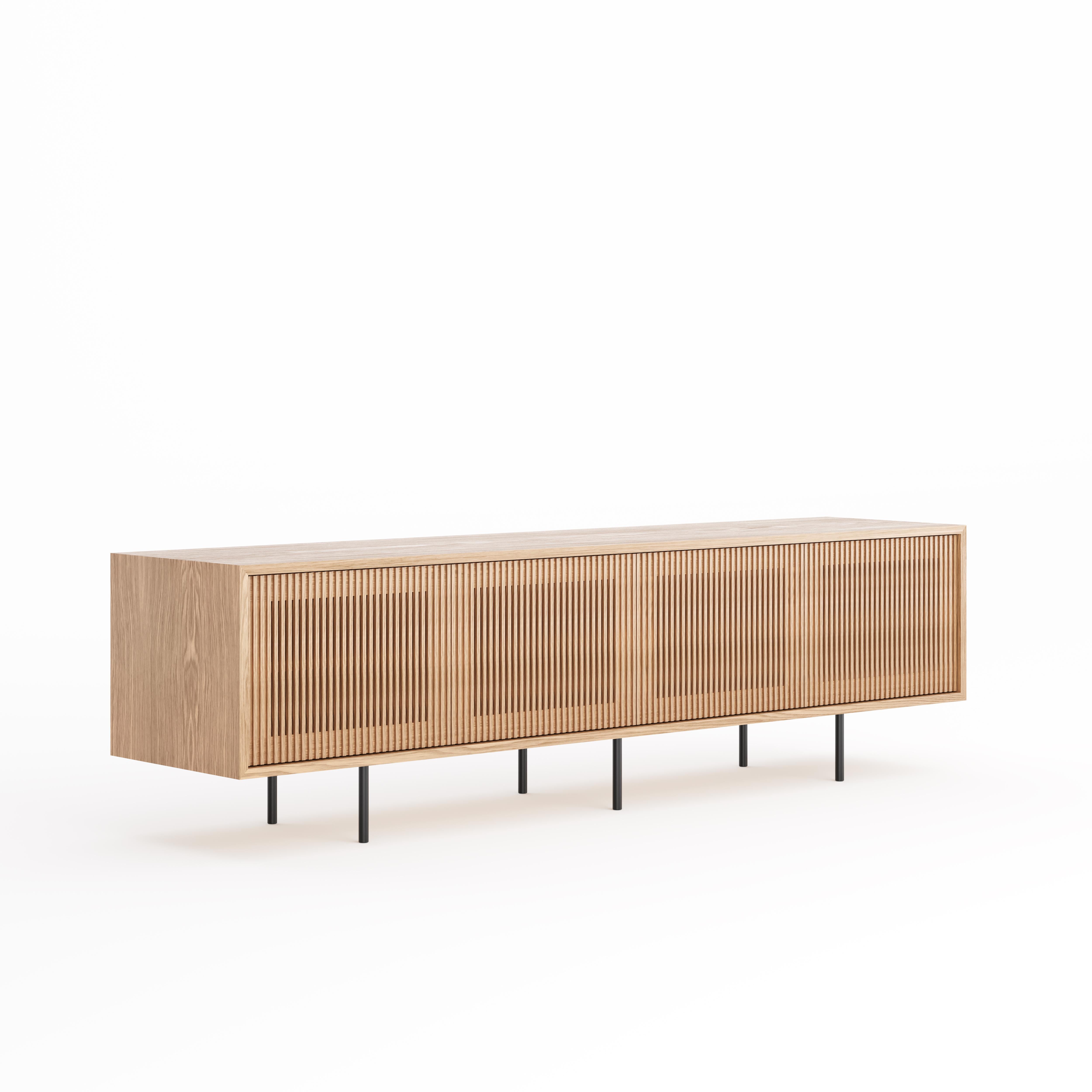 Long oak sideboard with four slatted doors and simple aluminum black legs in mid century modern style.
Perfect as a sideboard, TV stand, record player and vinyl storage for music enthusiasts. This long sideboard offering spacious storage for