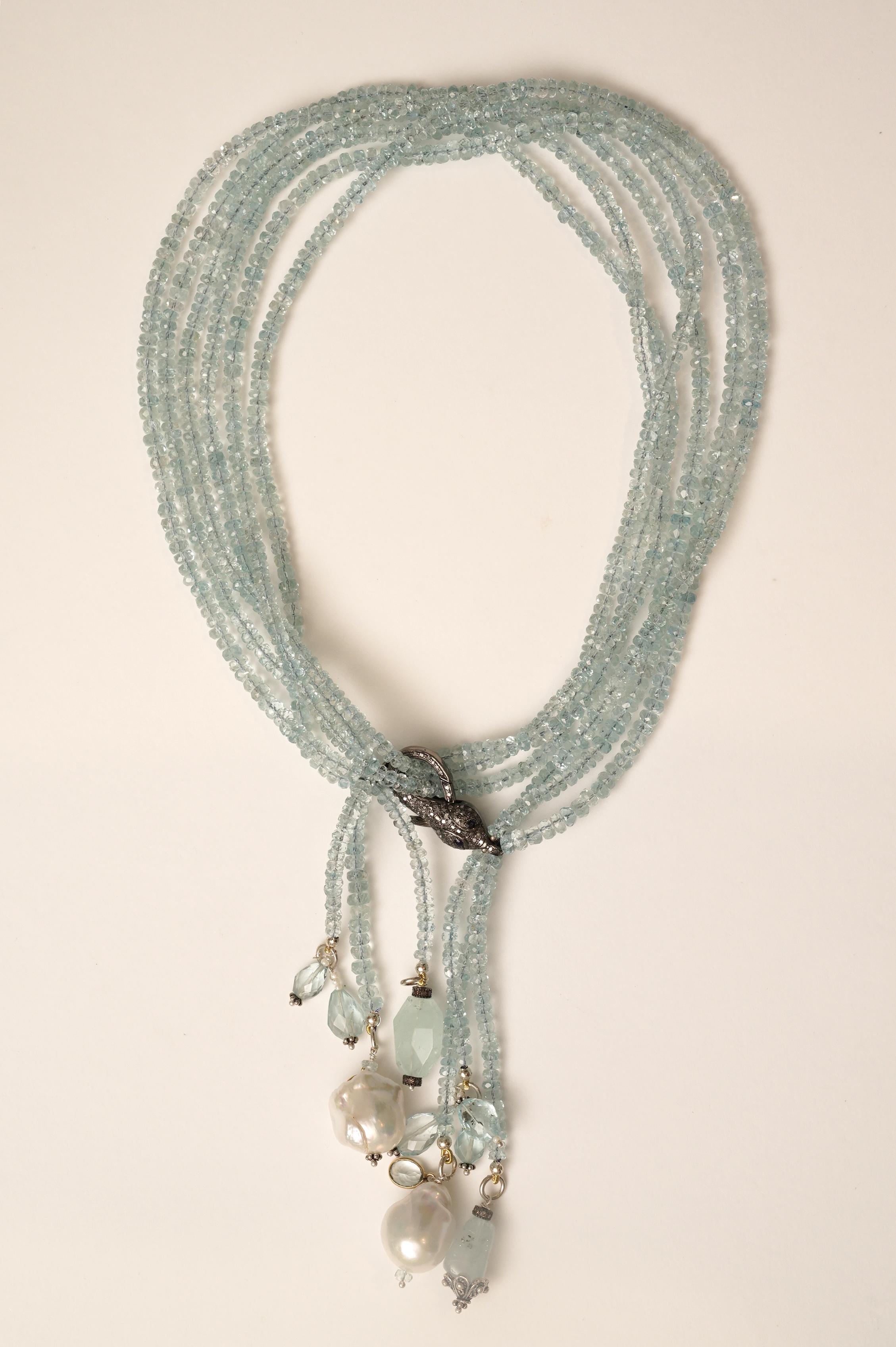 A multi-strand necklace of faceted and fine aquamarines which can be worn long, or doubled and worn short.  When doubled 16.5 inches long.  The assortment of pendants includes baroque pearls, sterling pendants and diamond rondelles and average 4