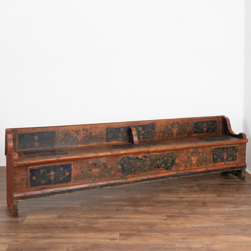 Antique hand painted bench with divided storage at over 8' long .
Traditional Eastern European folk art painting with blue background and red, green and yellow florals.
Two bench seats open to reveal interior storage.
Restored, strong and stable.