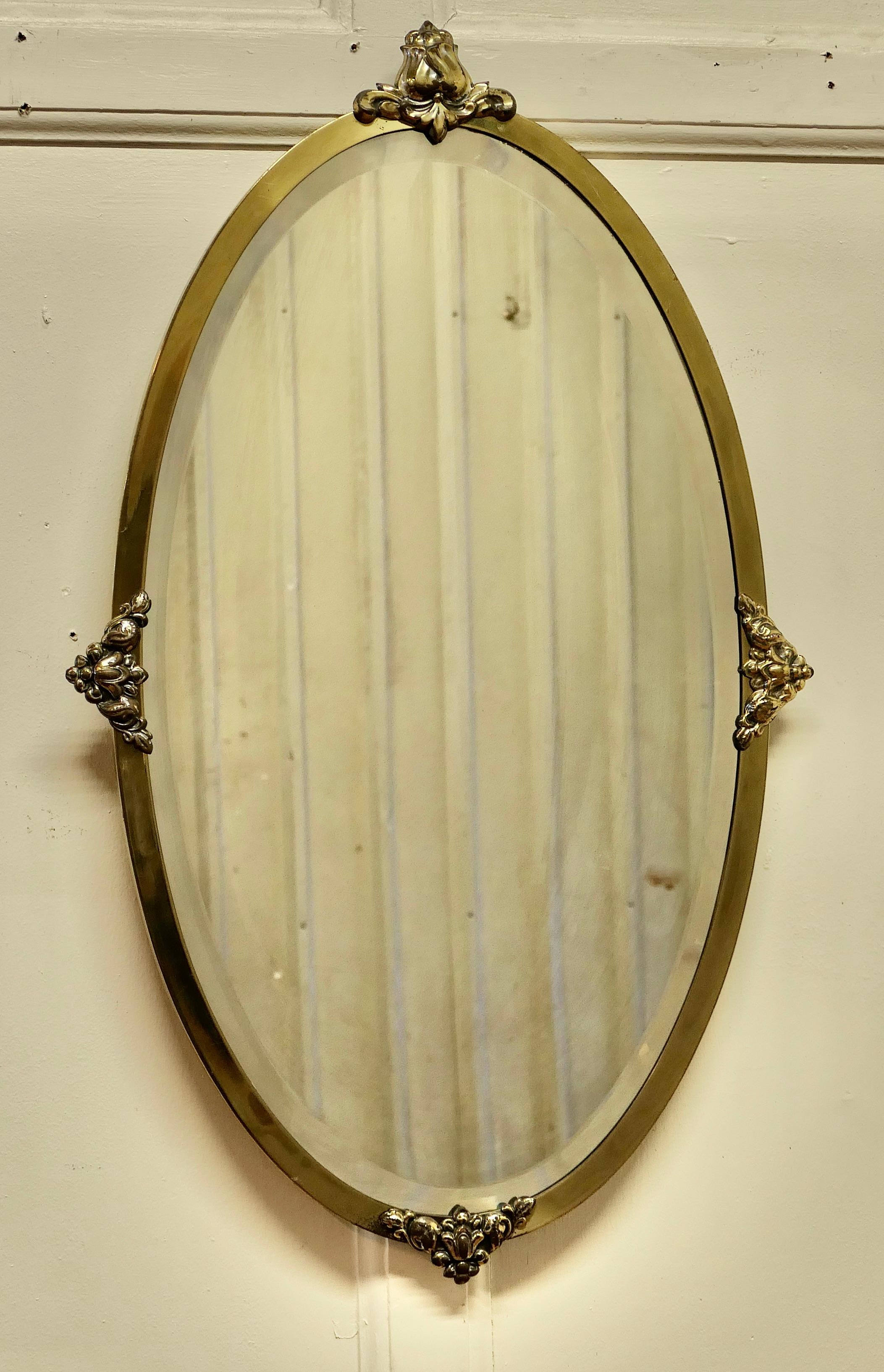 Long Oval Art Deco Gilt brass wall mirror

The Mirror is Oval it is in brass and has decorative Art Deco Rococo Gilt decorations on the frame with a bevelled glass mirror
The mirror glass is original and in good condition with little or no foxing