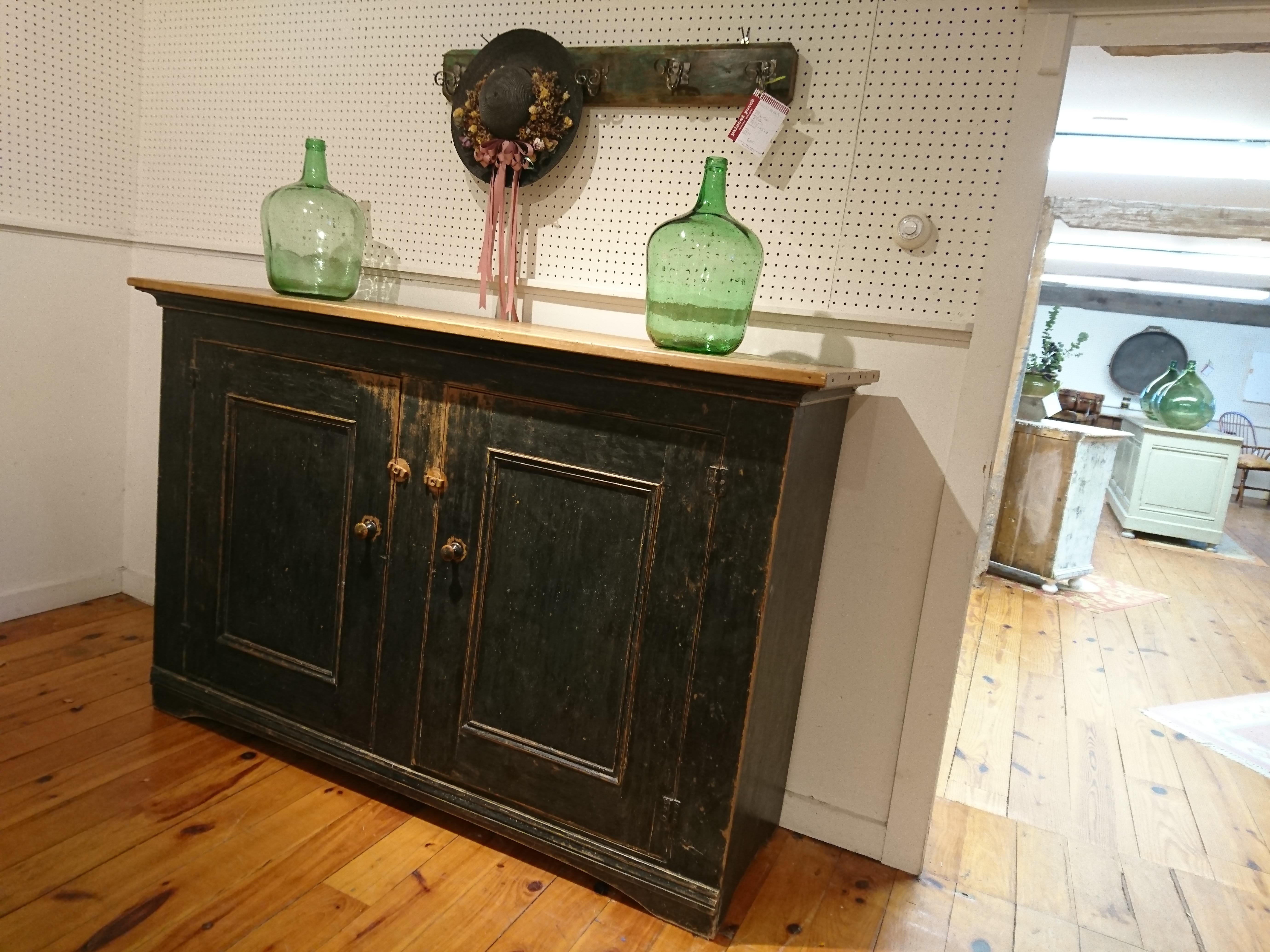 It is rare to find such a long two-door buffet that is also not too deep. This is not a massive piece but has enormous storage space with two inside shelves. The color is basically black, with tones of dark green and gray and a wonderful pine top.
