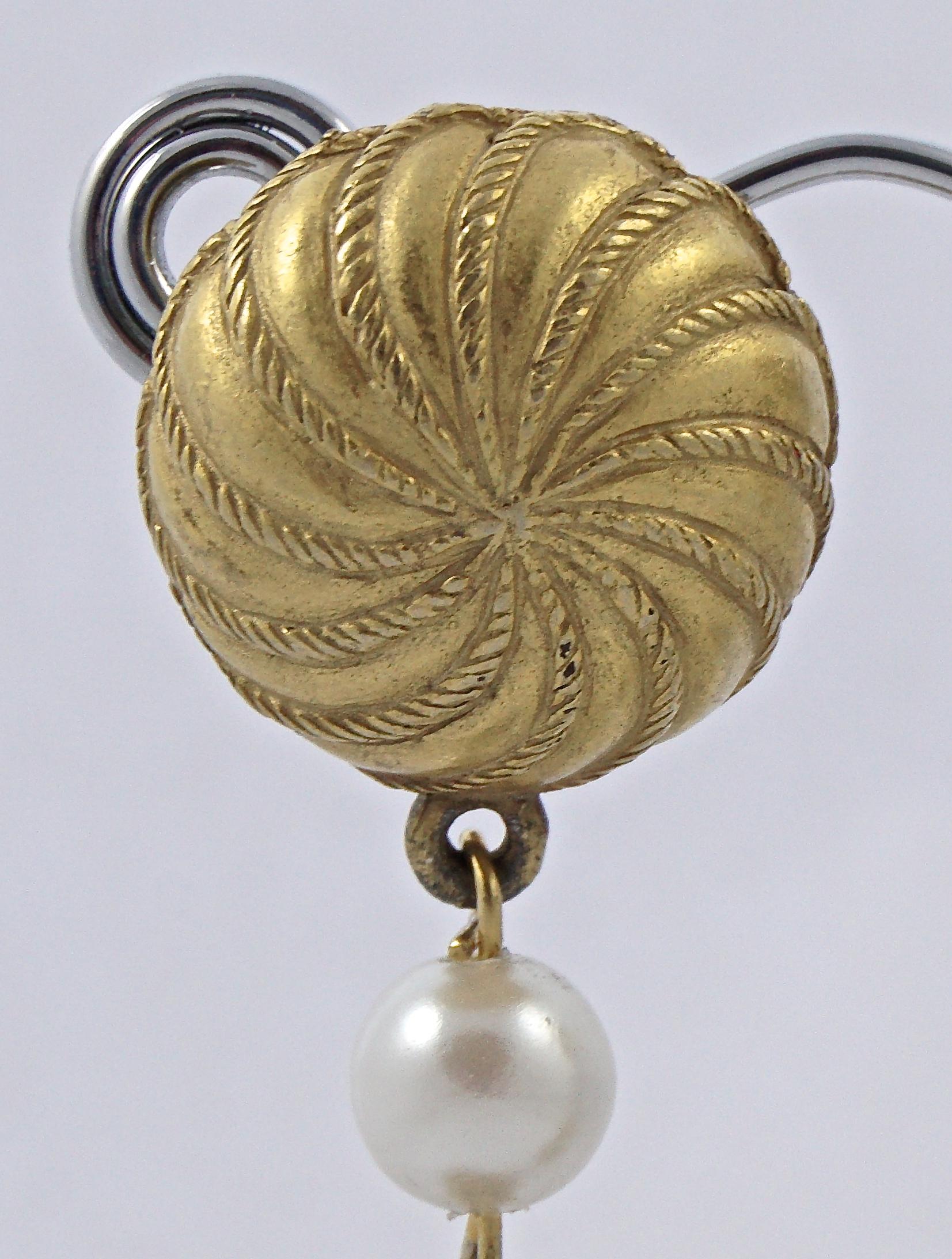 
Wonderful long pale gold plated drop clip on earrings, featuring a lovely rope twist swirl design, and white faux pearls. Circa 1970s. Measuring length 8.9cm / 3.5 inches, and the drop is width 2.55cm / 1 inch. There is some wear to the gold