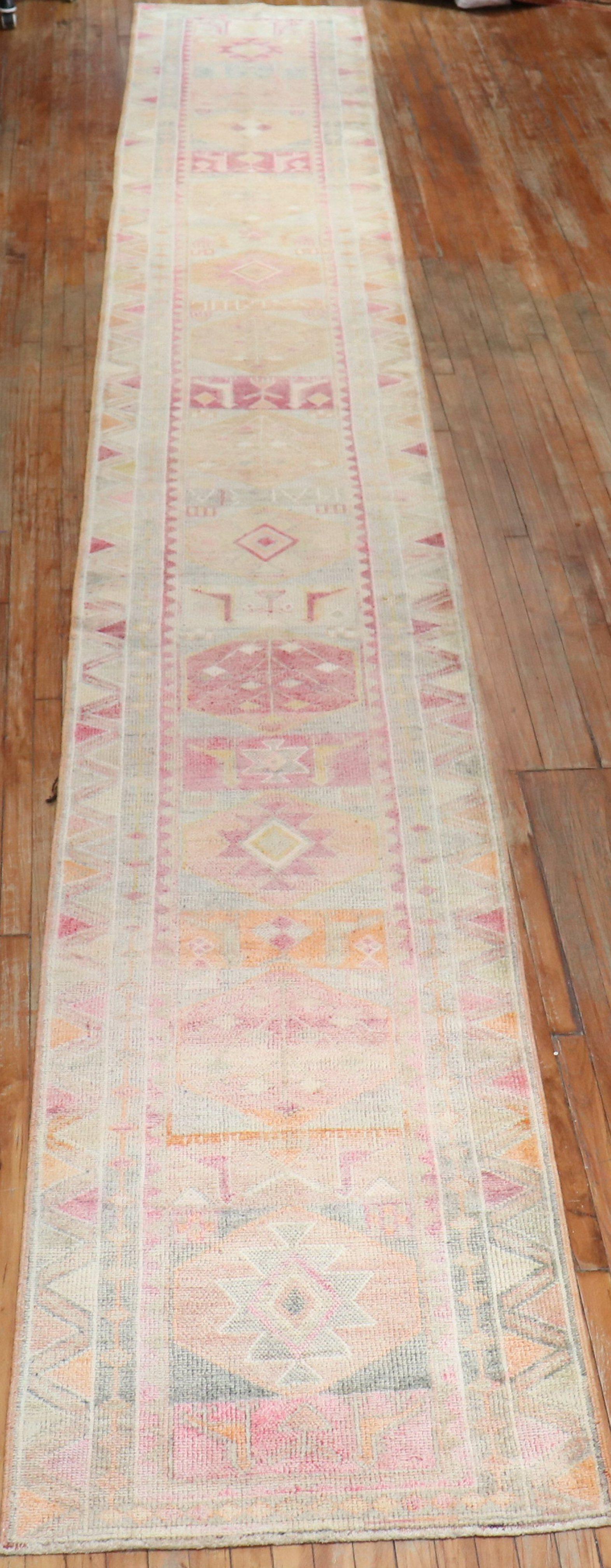 A rare size late 20th-century Turkish geometric runner in pastel tones. pretty pinks , orange and cream accents. Hope you have a long hallway for this!

Measures: 2'10