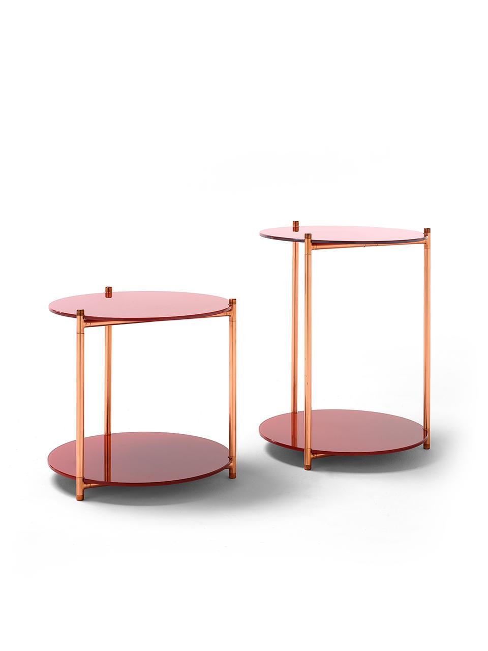 The Long Playing side tables stem from the eponymous étagère and feature the same play of materials: an essential but rich copper structure supporting two circular shelves made of back-painted glass. The rich warm metal of the base plays beautifully