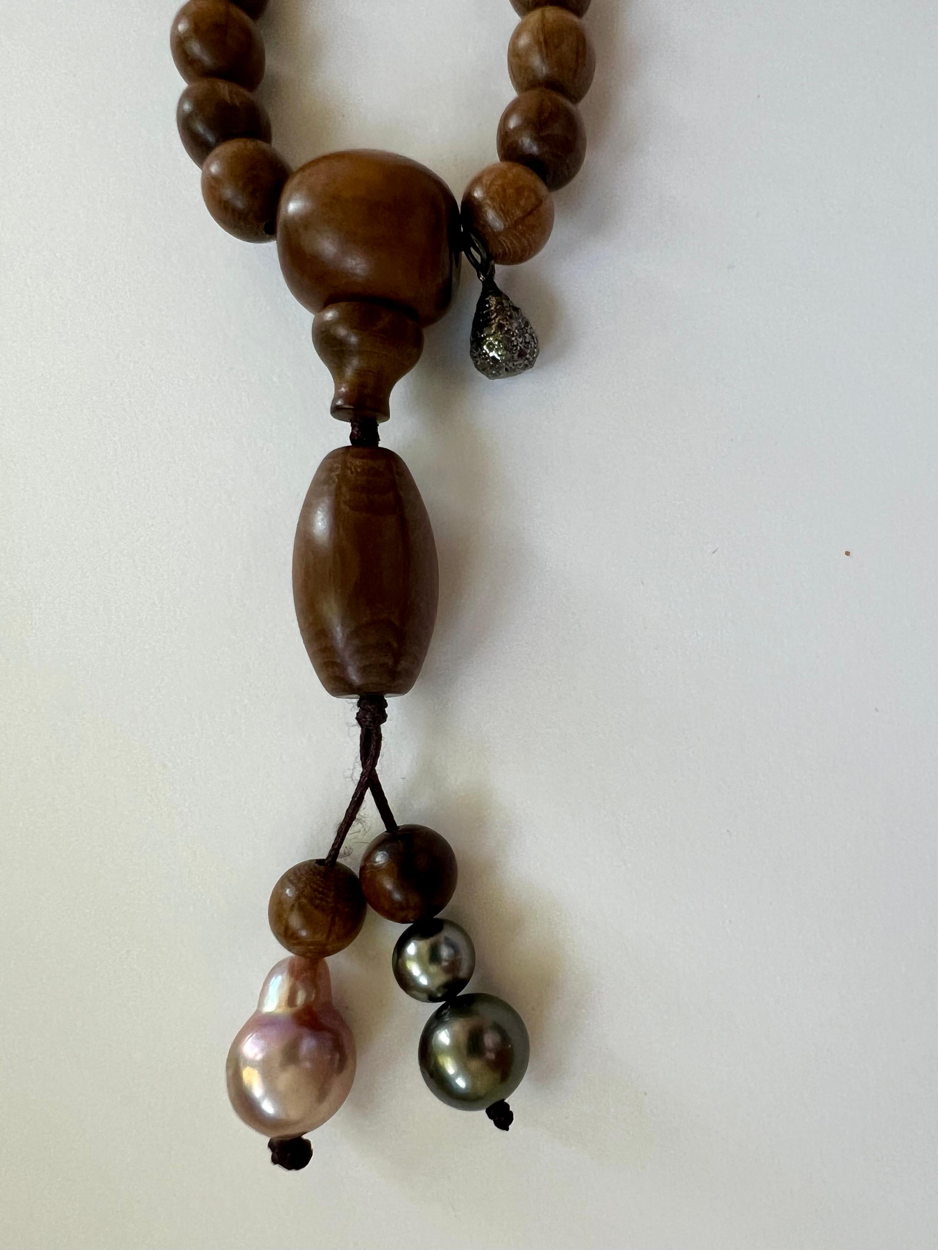 A long wooden bead necklace, inspired by Buddhist prayer necklaces. This necklace has a unisex length and can be worn around the neck once or twice or in several layers as a bracelet. 
Its full single length is 30 cm plus 10 cm tassel. 

The