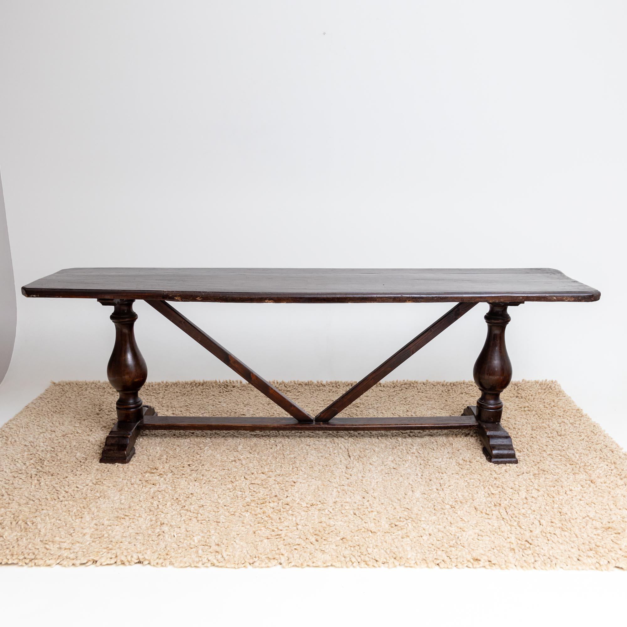 Elevate your dining space with this exquisite large walnut dining table. The table features baluster-shaped legs and a center bar with cross-bracing. Its expansive rectangular table top offers ample room, making it perfect for hosting gatherings or