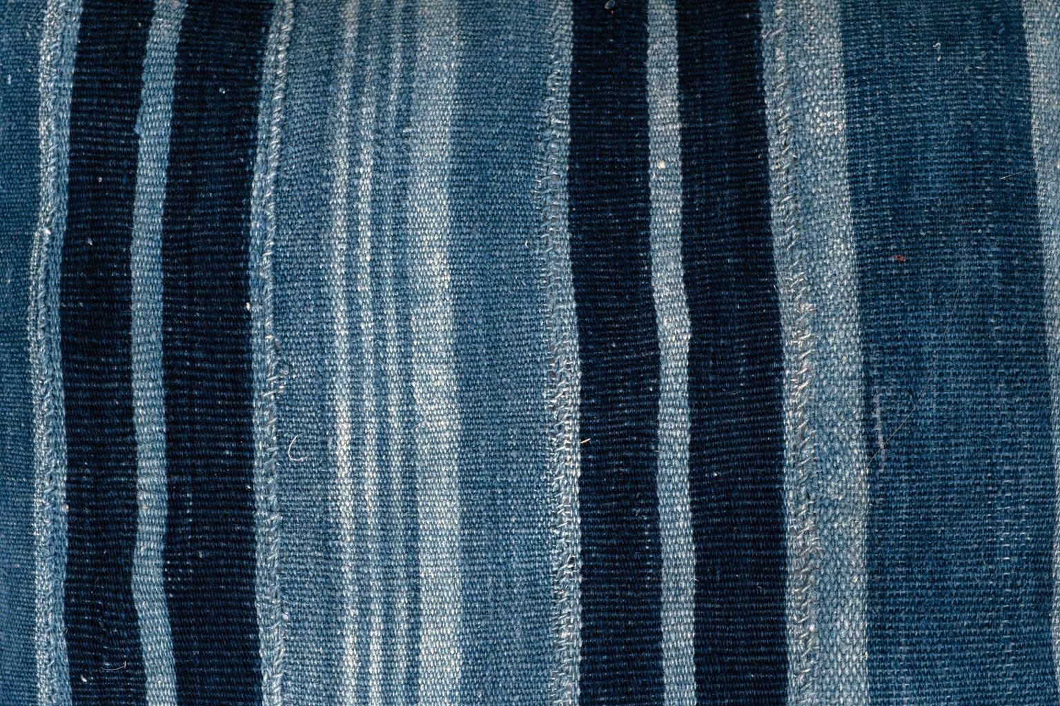 Langes, indigoblau gestreiftes Lendenkissen aus handgewebtem und handgefärbtem Baumwollstoff. Dieses dekorative Kissen hat einen Reißverschluss und eine Federeinlage.