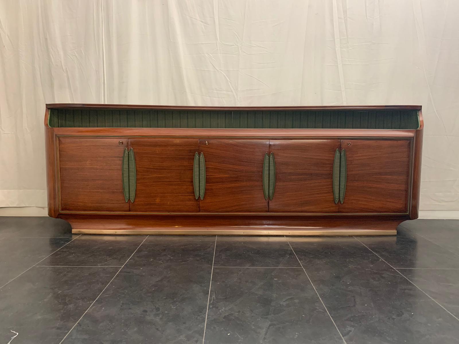 Superb rosewood sideboard by Vittorio Dassi, made in Italy in the 1950s. Rosewood structure with 2 four doors compartments and 1 single central compartment with 4 maple drawers. Furniture finely worked and built with long curved lines, carved and