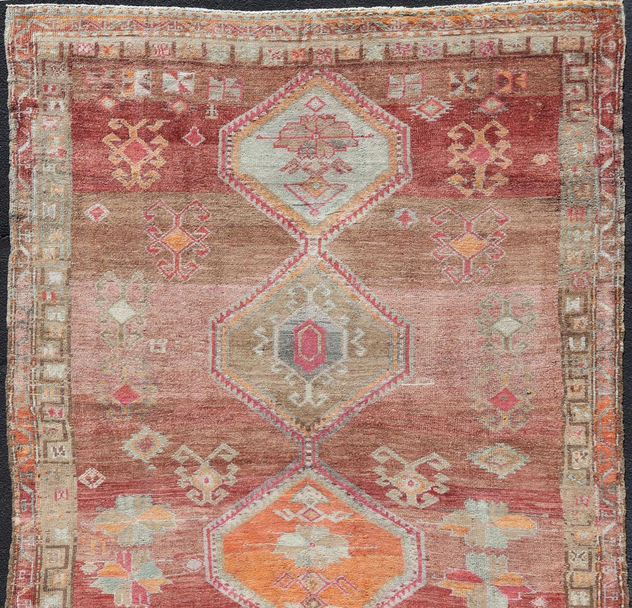 Turkish tribal design colorful gallery runner in soft red and multi colors, rug EN-179883, country of origin / type: Turkey / Oushak, circa 1930

This expansive Gallery rug from Turkey features a colorful pattern of unique tribal medallion