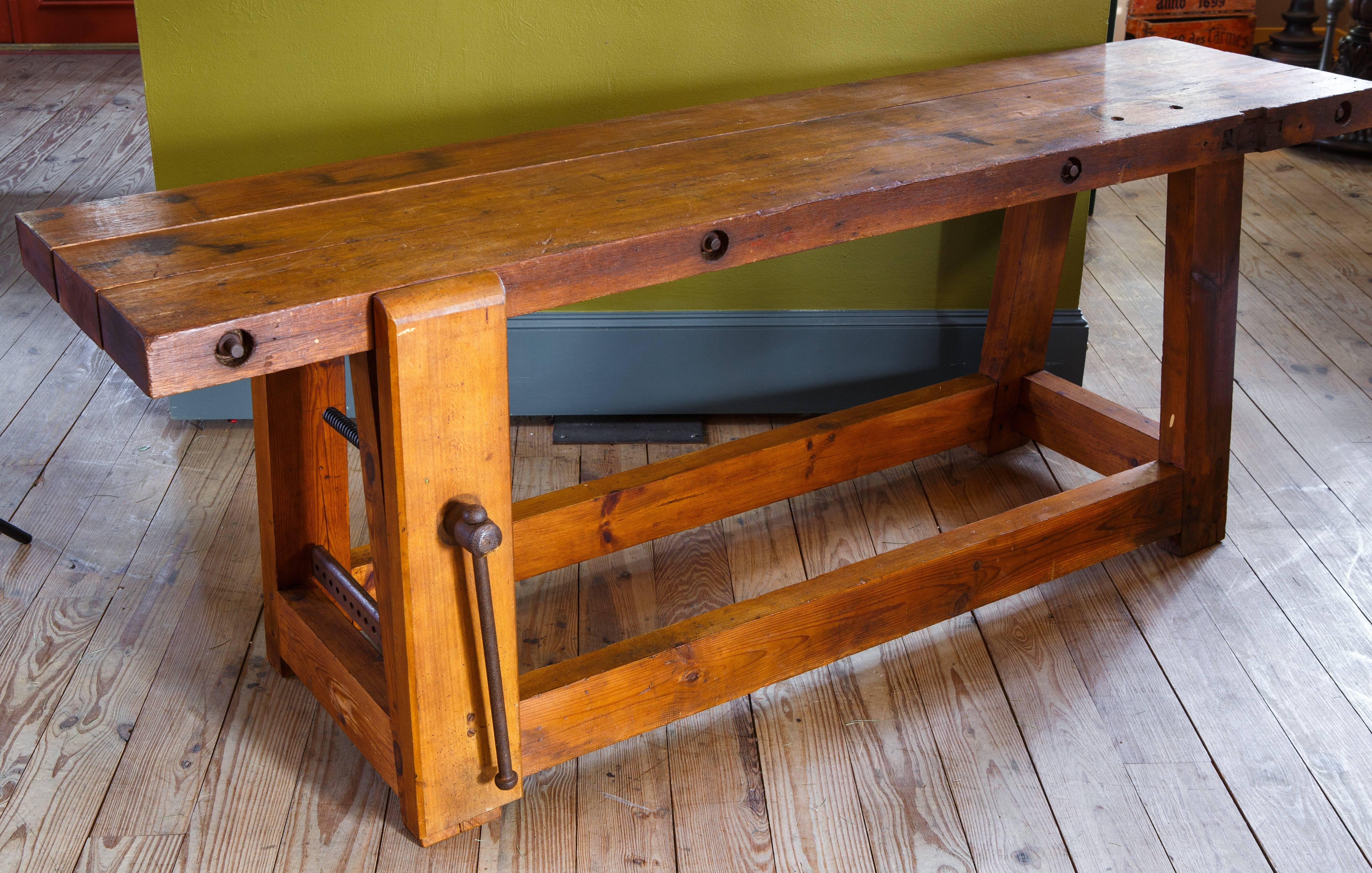 All original wooden workbench/ worktable from Belgium, circa 1920. Includes the original metal and wood clamp/vise on one side. Entire piece is handmade. Interesting rustic and Industrial hybrid style. Would make an excellent work bench, console