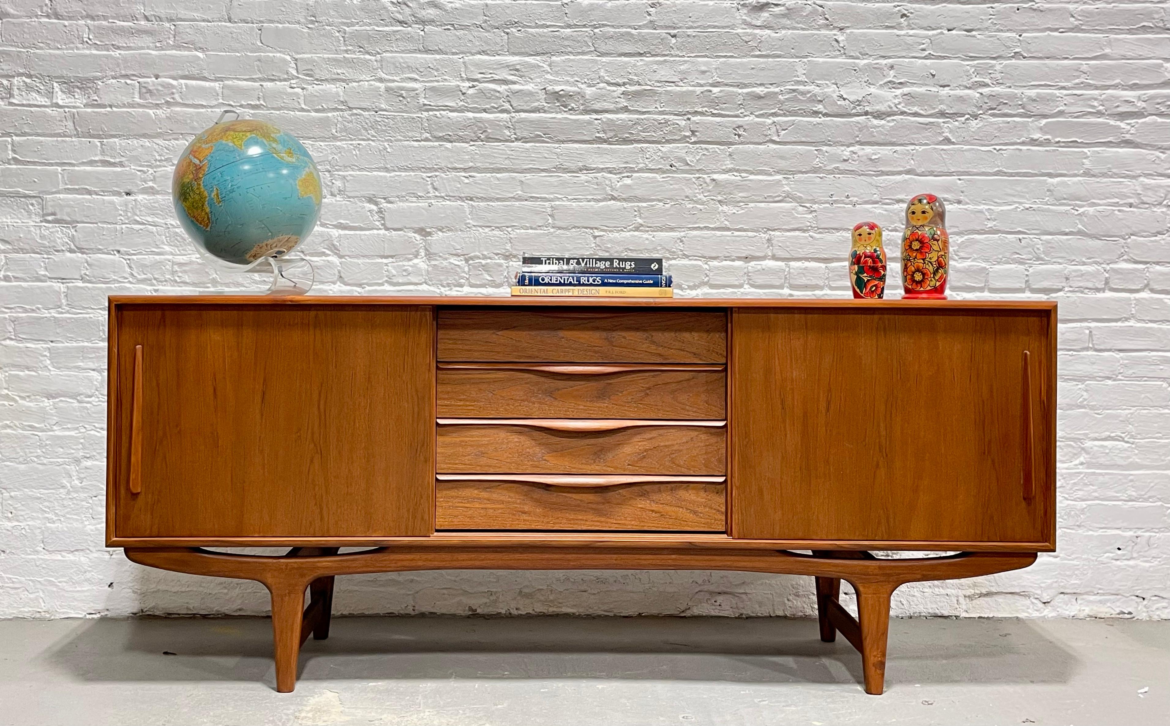 Long + Sculpted Mid Century Modern styled credenza / media stand featuring sculptural hand pulls and leg design. Excellent layout for a media stand - generous shelving for components paired with streamlined drawers for remotes, dvds and other
