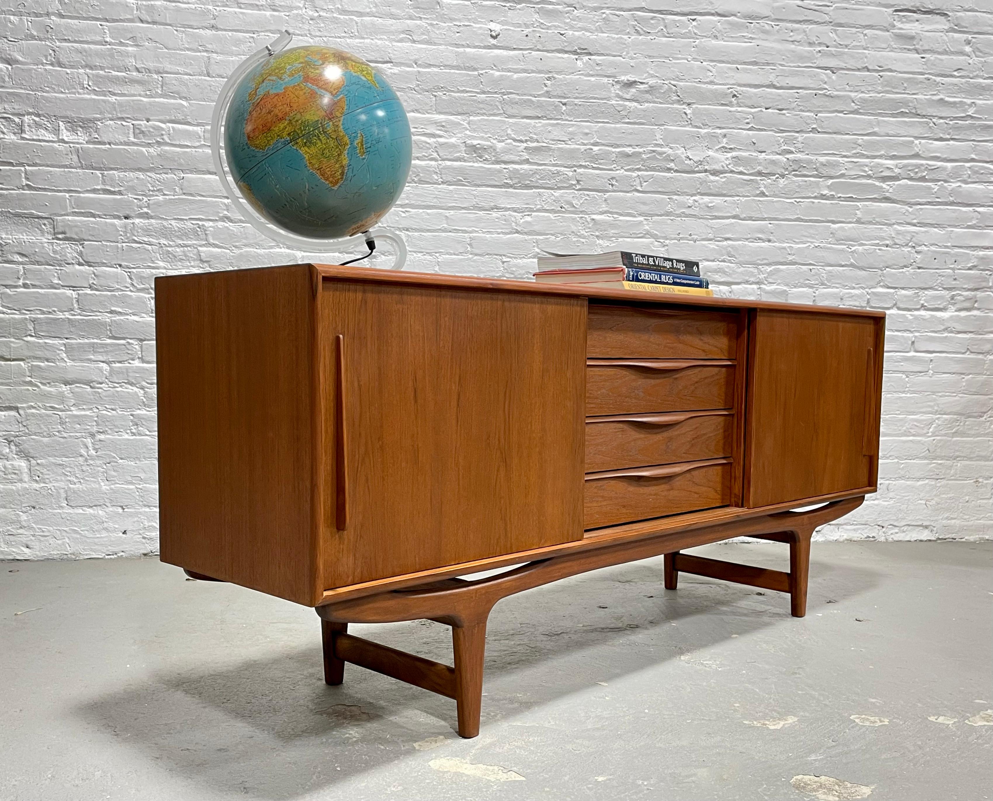 Long sculpted Mid-Century Modern styled credenza / media stand featuring sculptural hand pulls and leg design. Excellent layout for a media stand - generous shelving for components paired with streamlined drawers for remotes, dvds and other