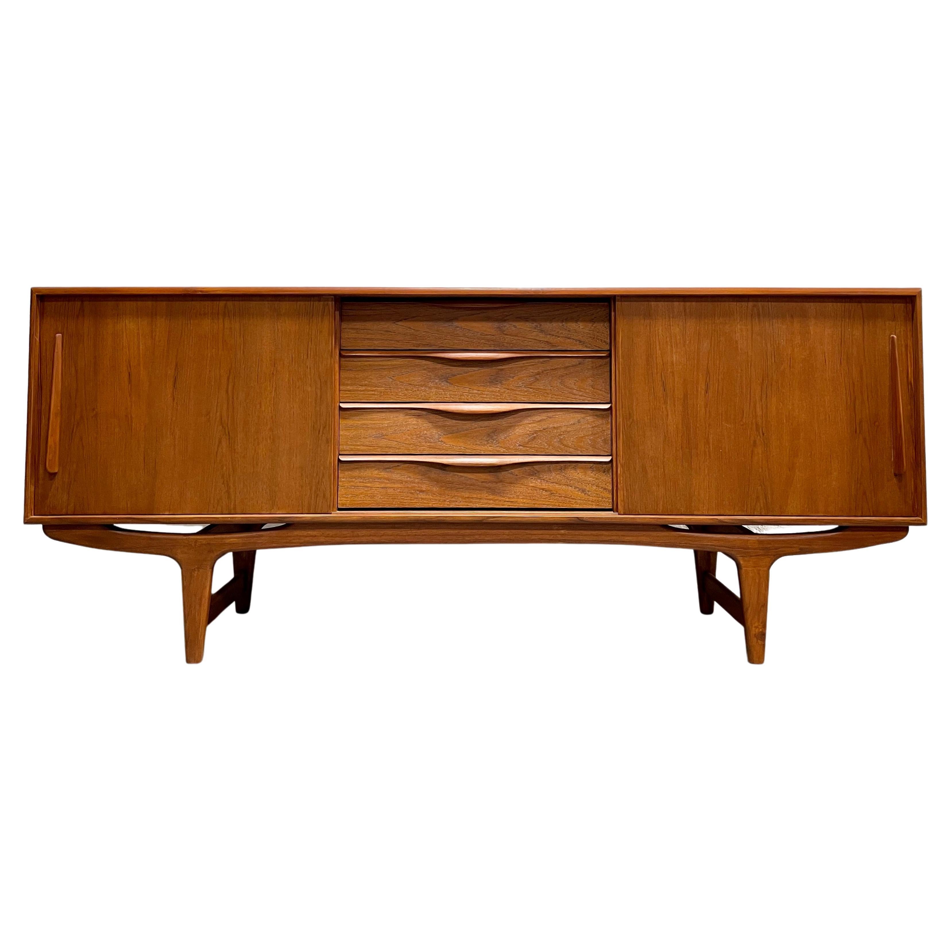 Long sculpted Mid-Century Modern styled credenza / media stand featuring sculptural hand pulls and leg design. Excellent layout for a media stand - generous shelving for components paired with streamlined drawers for remotes, dvds and other