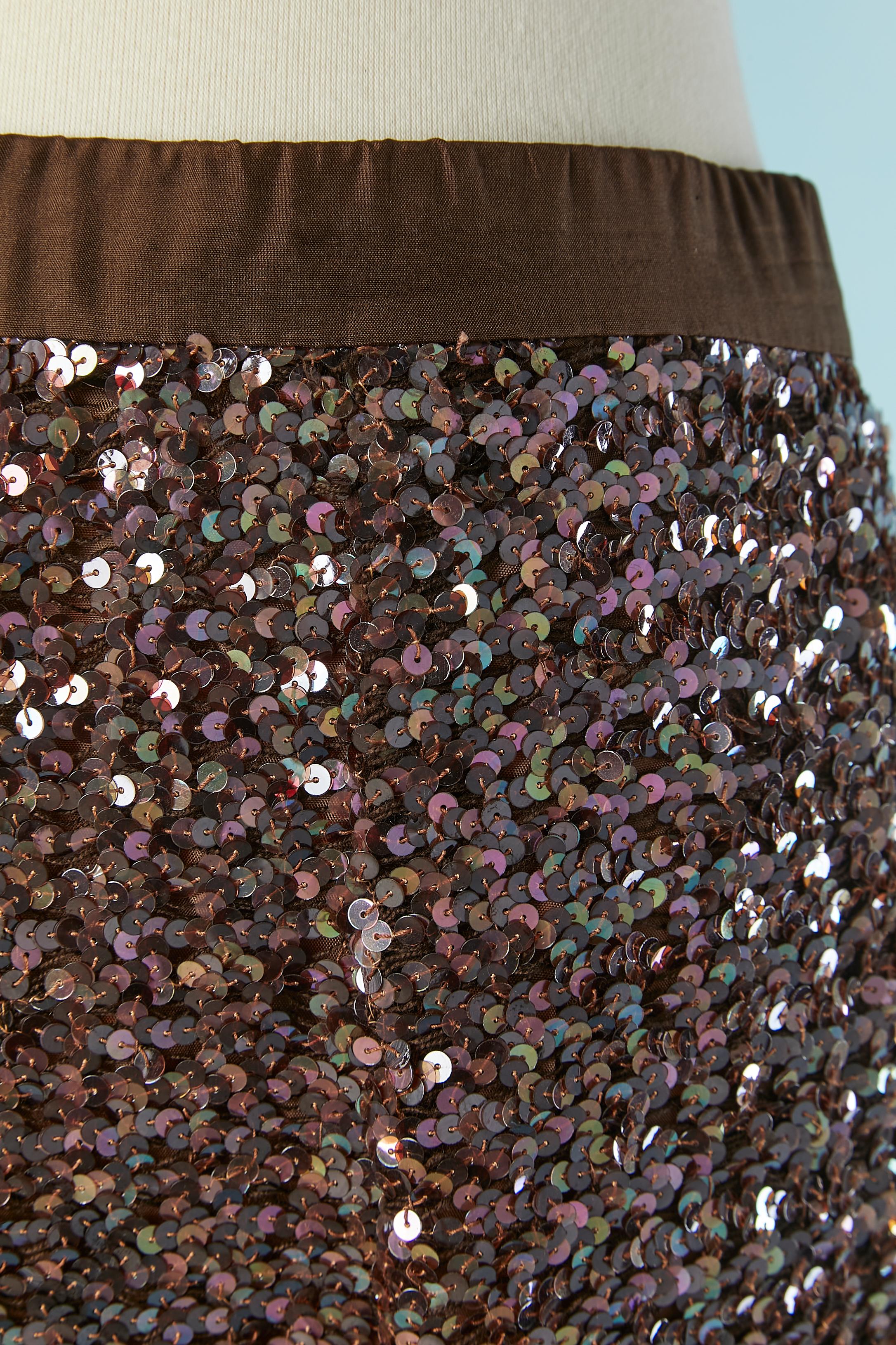 Longue jupe à paillettes. Fermeture auto-agrippante et zippée au milieu du dos sur la taille. Fente au milieu du dos, longueur = 48cm
Les paillettes sont cousues sur un tricot extensible et la doublure est probablement en acétate ou en polyester.