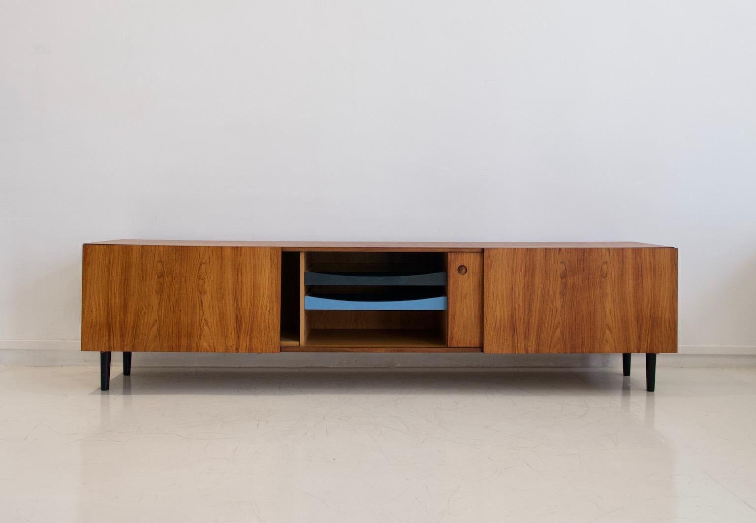 Ib Kofod-Larsen rosewood sideboard. Front with sliding doors, behind which are shelves and drawers, later painted in blue and grey colors. Later mounted stained wood legs. Manufactured at Faarup Møbelfabrik in the 1960s. Surface has been restored.