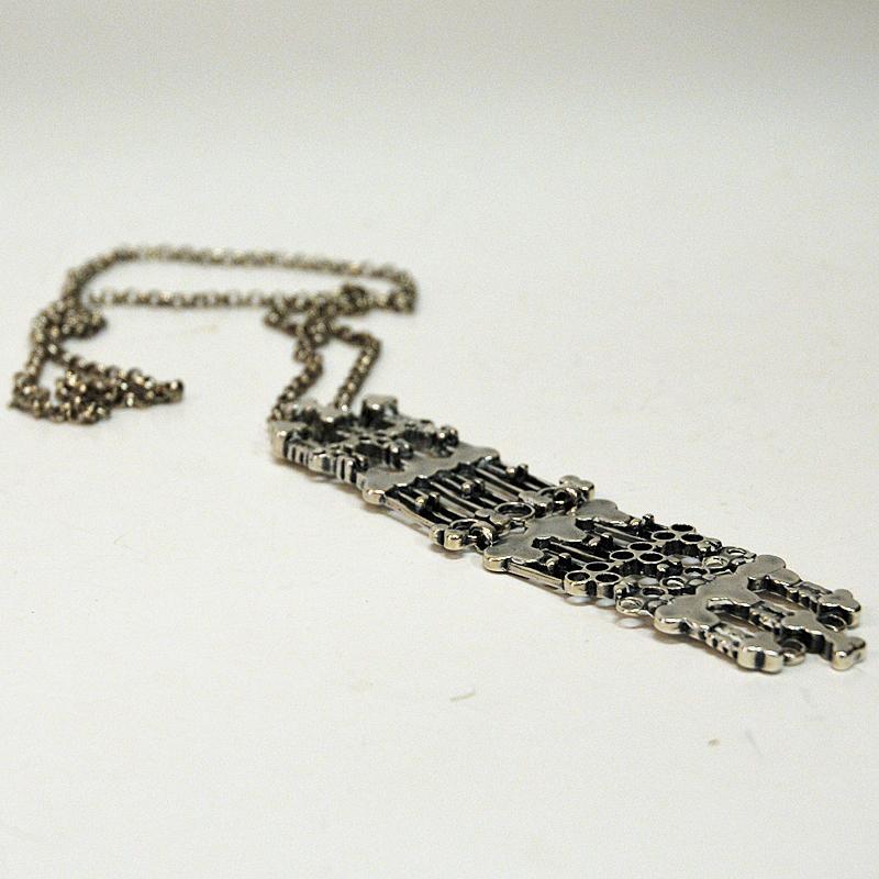 Hübsche Silberkette von der Designerin Marianne Berg für Uni David-Andersen 1960er Jahre Norwegen. Dies ist ein zweiteiliger, längerer Anhänger mit von Wikingern inspirierten Mustern an einer langen Silberkette. Ein hervorragendes Beispiel für den
