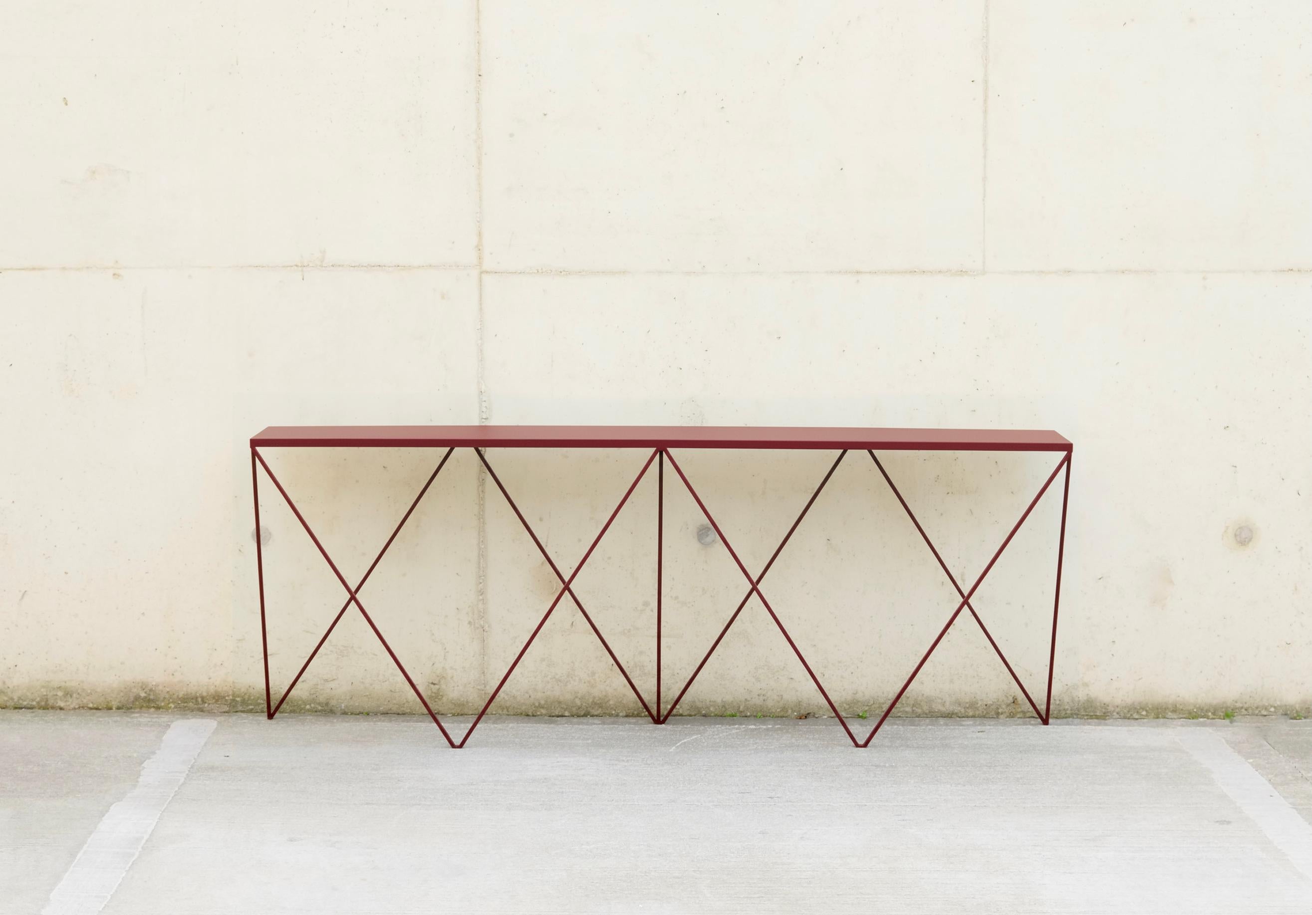 A beautiful long slim Giraffe Console Table made with a powder coated steel frame and a linoleum table top. This piece is finished with a beetroot colour frame and a colour matched burgundy linoleum table top. The top is made out of environmentally