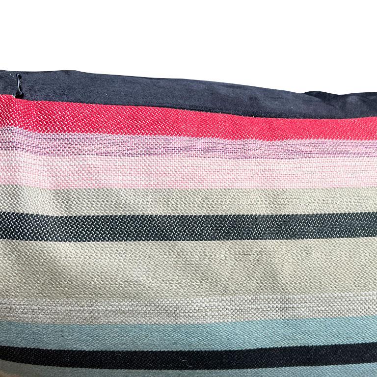 A gorgeous and large bright stripe lumbar pillow in pink, blue, green, and black. This large custom pillow was created using a discontinued Sunbrella fabric. Which means it will be great outdoors and hold up against the elements. The alternating