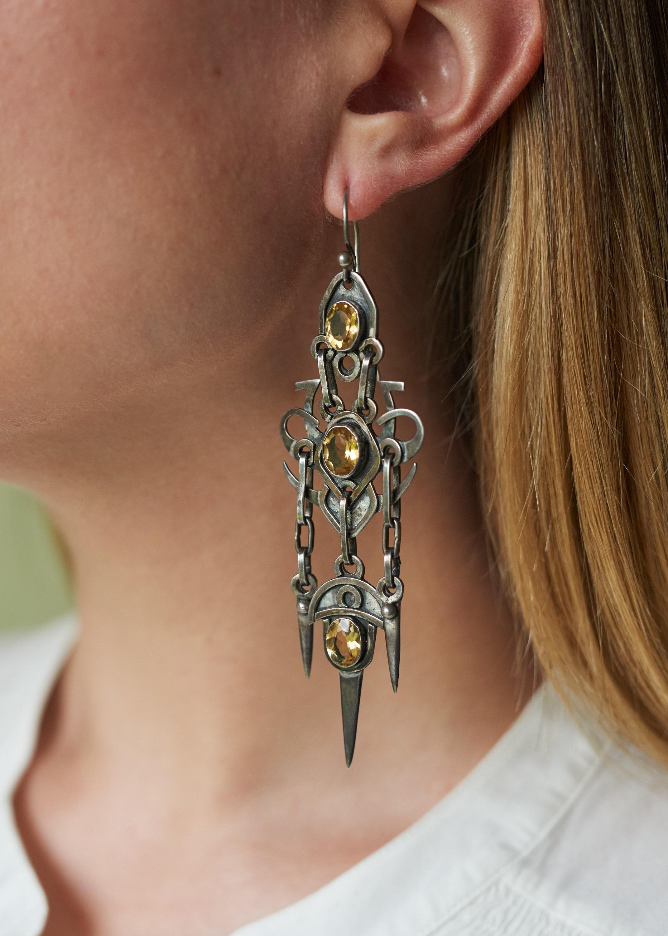 A pair of Arts and Crafts style citrine and silver dangle earrings. Stamped 925. Earrings measure 4.25
