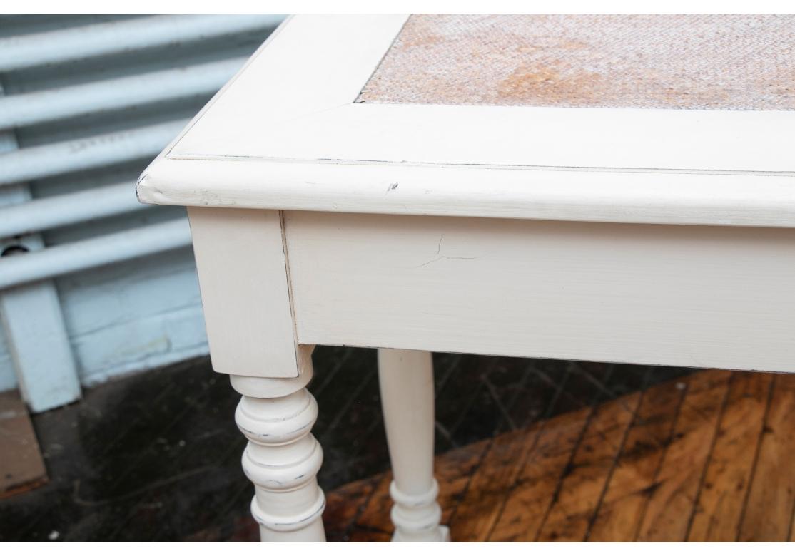 A well made and bright Console Table suitable for any number of applications with a useful see-through quality. In a semi antiqued white painted finish with inset white washed woven top. The turned legs with turnip feet. 
L. 70 3/4