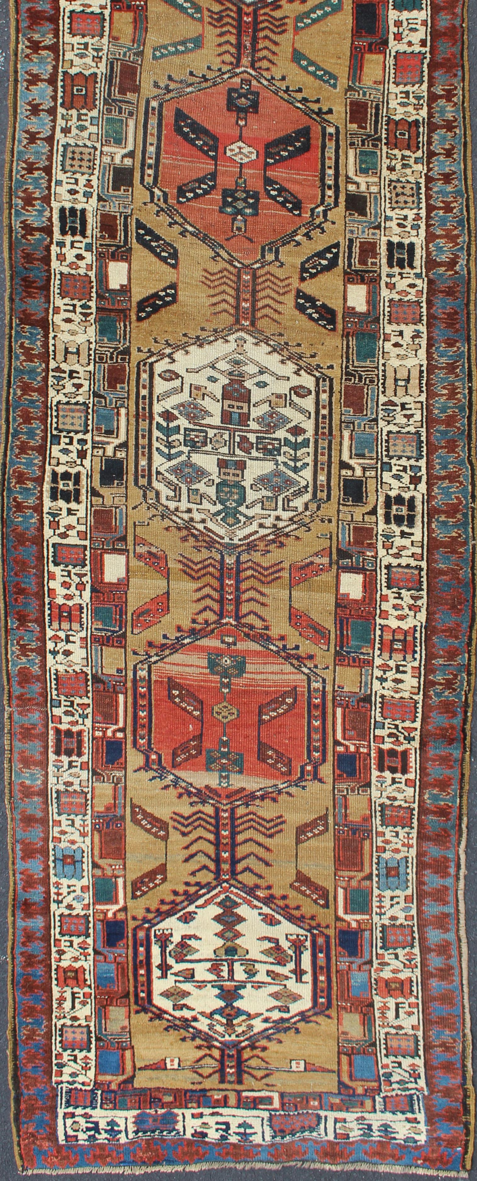 Antique Persian Tribal Serab runner, rug/n15-0501, origin/iran.

The camel field in this piece is decorated with ivory strap work, navy blue lattice work and stylized Boteh and floral elements. A beautifully drawn reciprocal trefoil guard border