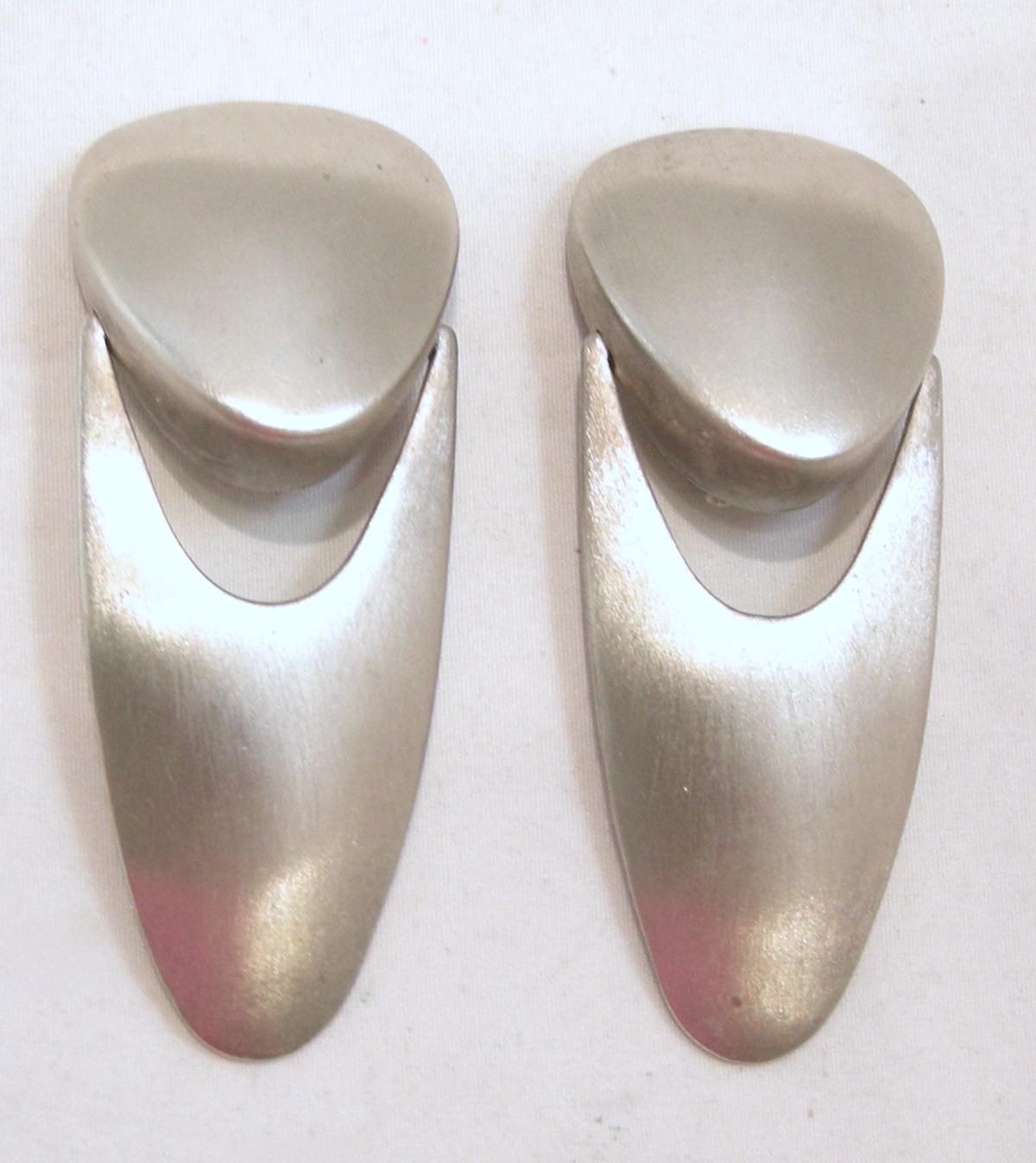 These long vintage 1970s earrings feature a modernist design with a triangular shape top earpiece and attached drop, all in a matte-finish silver-tone setting.  In excellent condition, these clip earrings measure 2-7/8” x 1-1/8”.