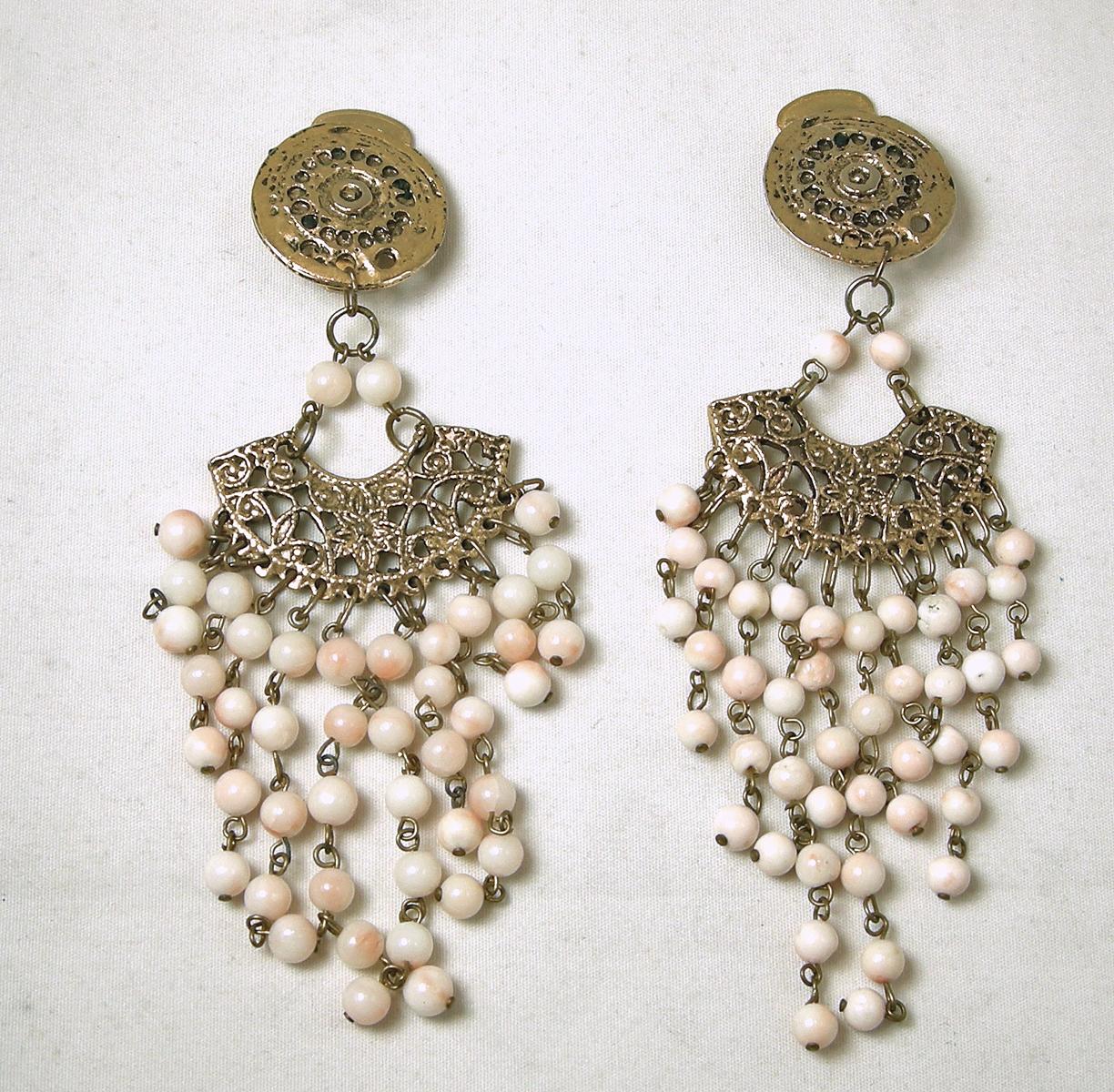 These long vintage earrings have a decorative antique gold tone top with dangling faux angel coral beads.  These clip earrings measure 4-1/2” x approx 1-1/2” and are in excellent condition.