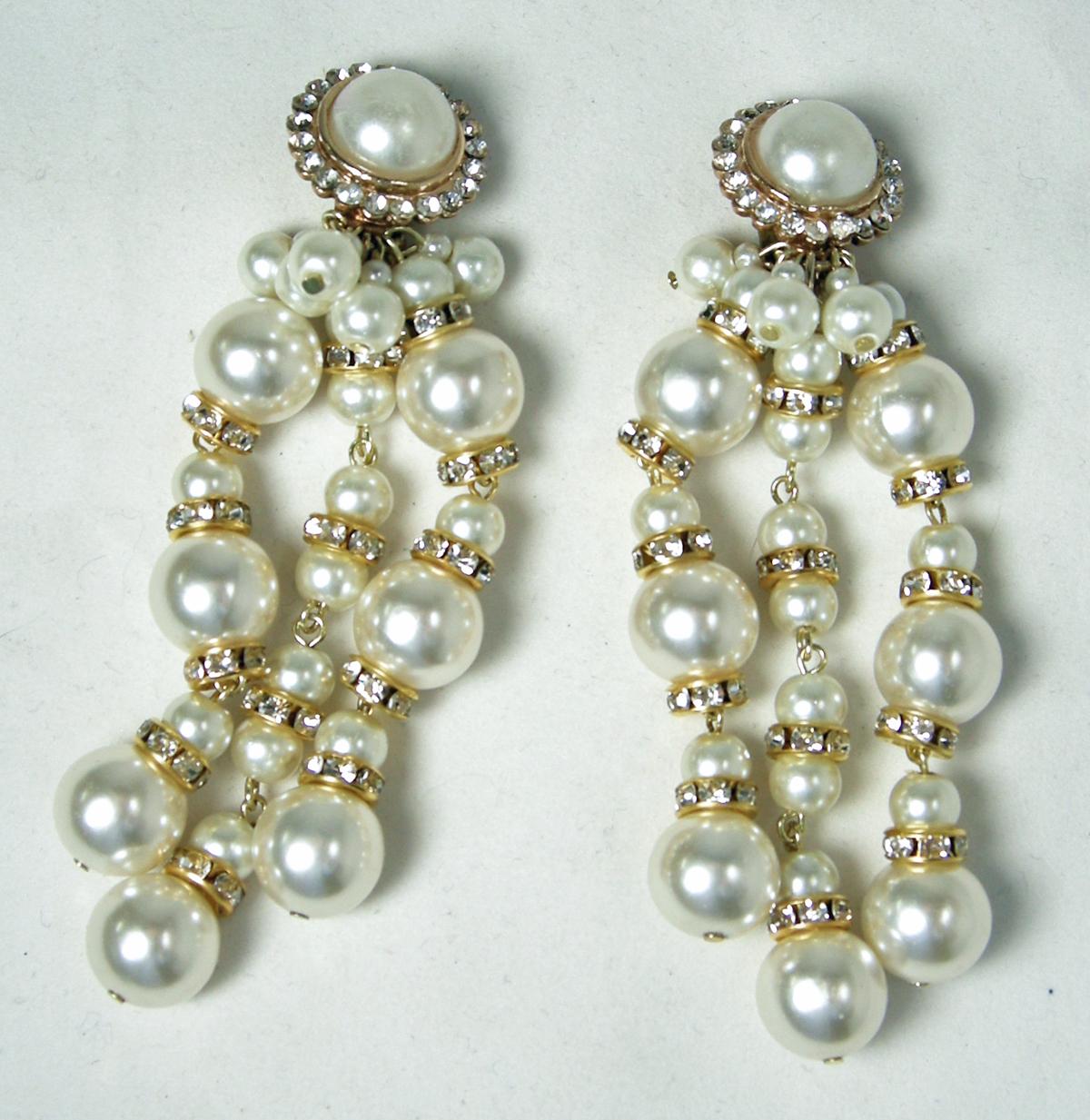 These long signed De Mario earrings have a top pearl center surrounded by crystals. The long drop has rows of faux pearls with clear crystal accents … in a gold tone setting.  In excellent condition, these clip earrings measure 3” x 1-1/4” and are