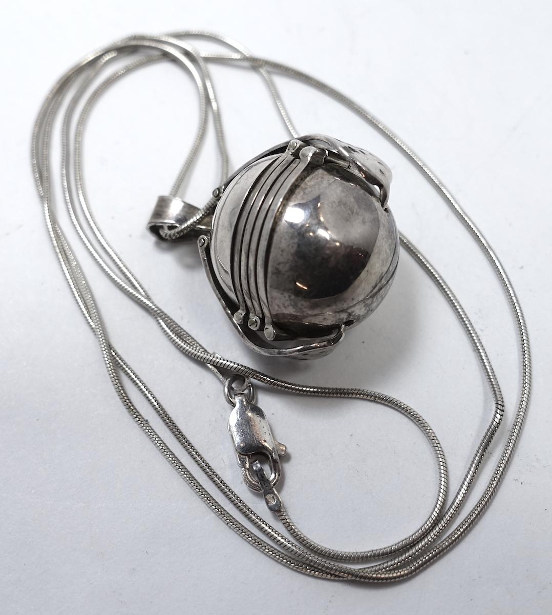 This vintage Art Deco photo locket holds 6 photos in a sterling silver setting.  The locket measures 3/4” x 7/8” and has two side clips.  It has a snake chain that is 22” x 1/16” with a spring clasp.  It has a “Taxco, Mexico” logo and is in