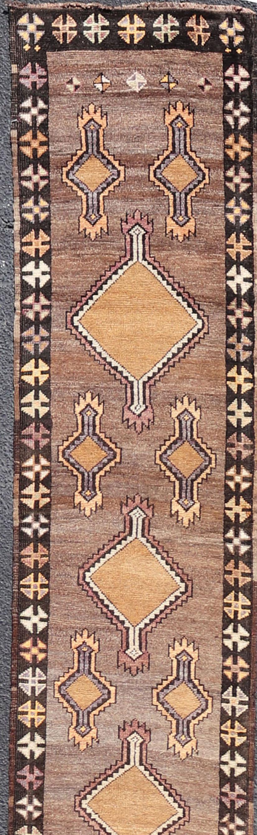 Long and narrow vintage turkish kars runner with Tribal design and Medallions in light purple, light orange, gray. Keivan Woven Arts / rug / EMB-9662-P13548, country of origin / type: Turkey / Oushak, circa 1940.

Measures: 2' x 16'10. 

This