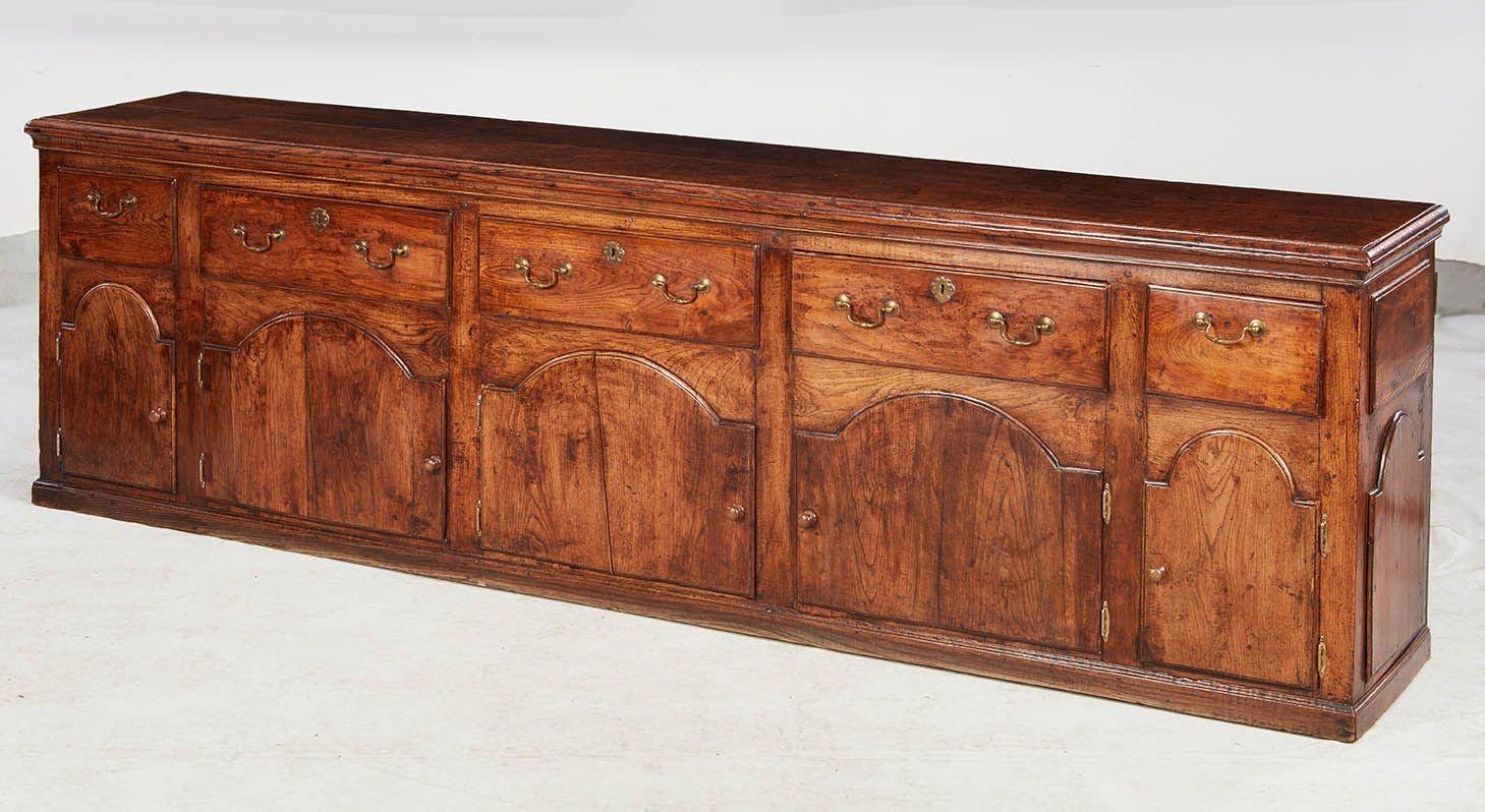 Une belle et substantielle armoire à vêtements, ou buffet, de plus de neuf pieds de long. Dessus à bords moulurés, au-dessus d'une série de cinq portes cintrées avec poignées de tirage, avec moulures cintrées assorties aux extrémités, chacune avec