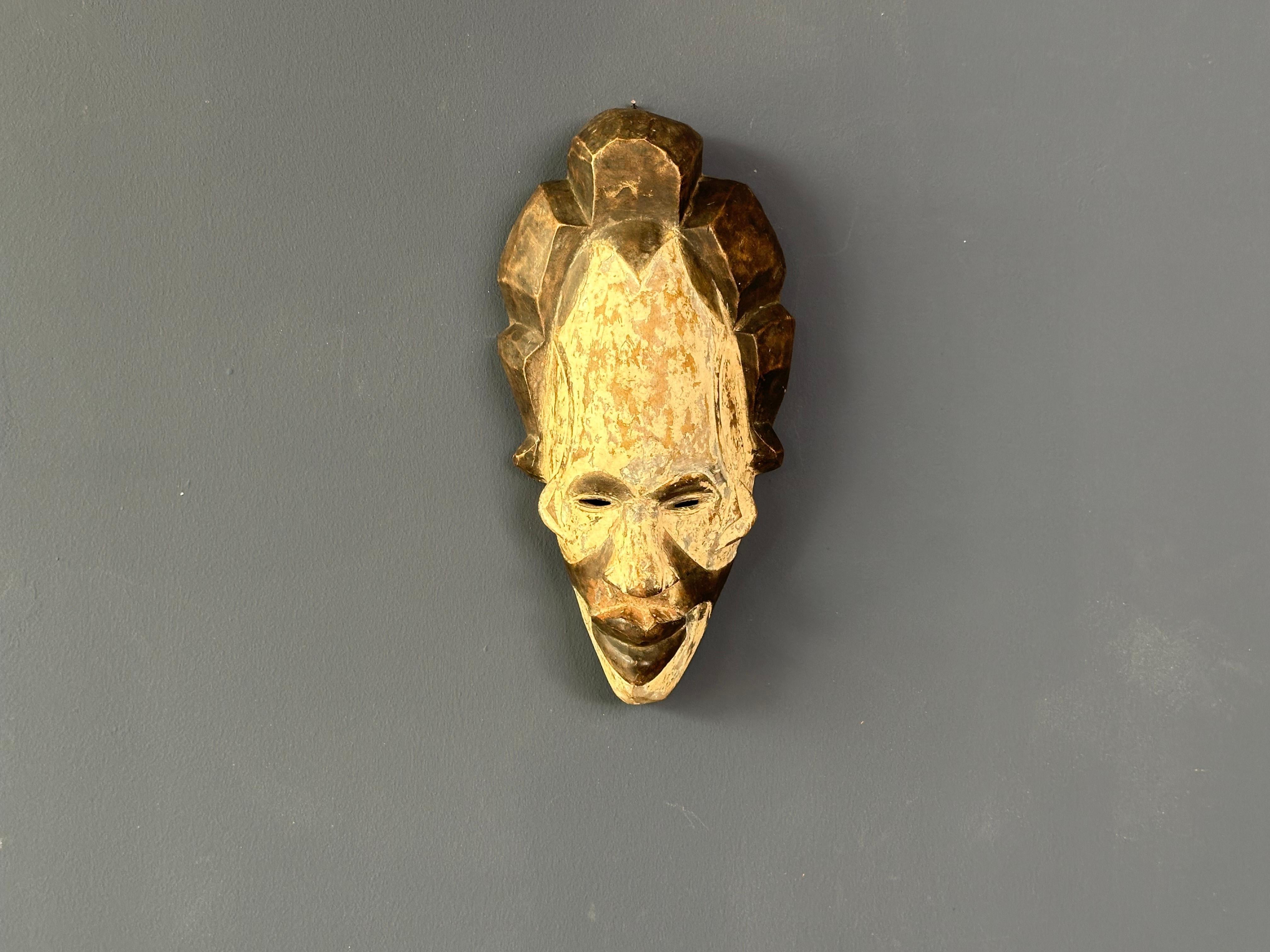Bringen Sie einen Hauch von Kultur mit dieser auffälligen langen weißen Tribal-Maske. Das filigrane Design und die langgestreckte Form machen ihn zu einem faszinierenden Dekorationsstück für jede Wand.