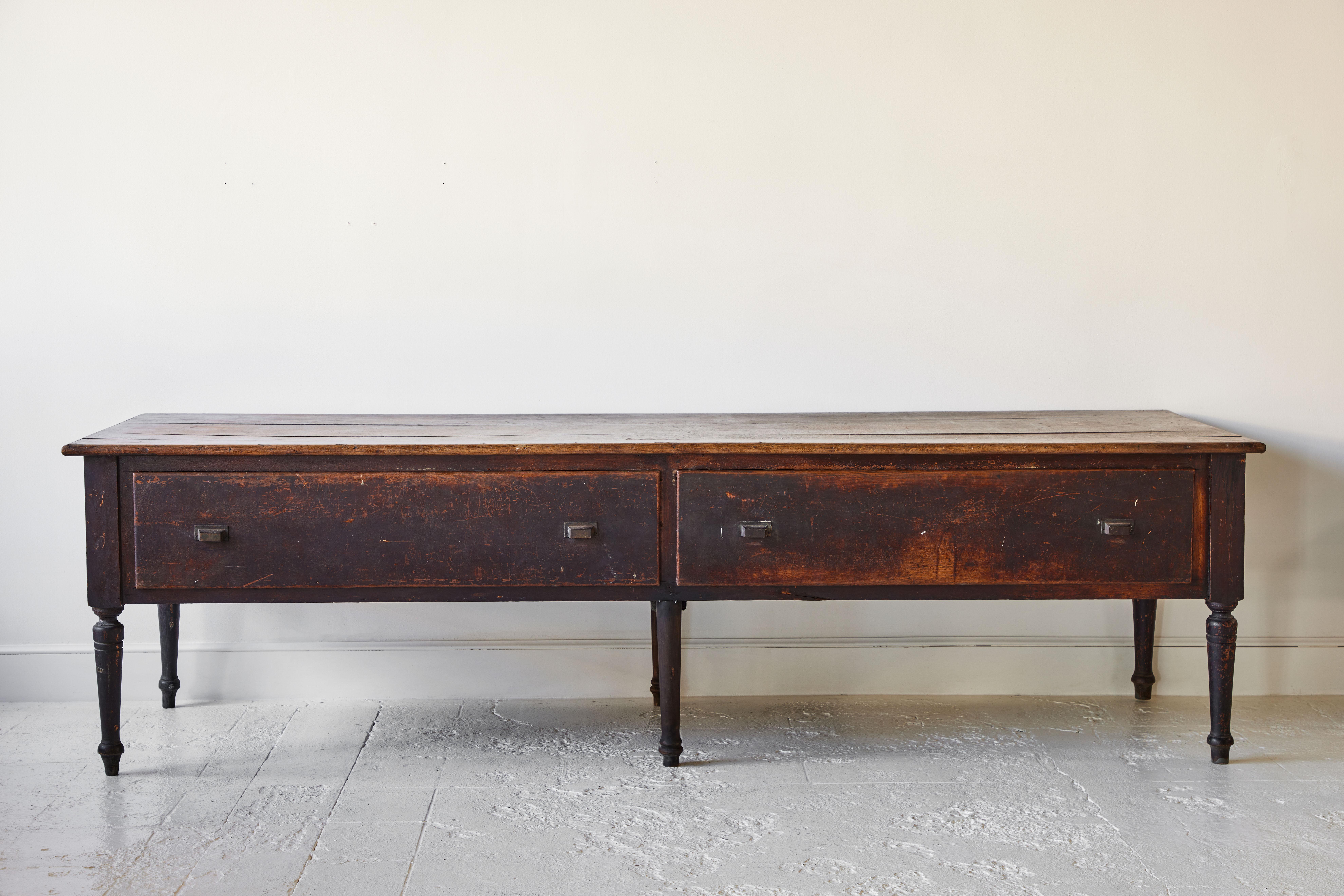 Beautifully crafted 1930s bank table with six turned legs and two drawers on the side, the wood is beautifully stained.