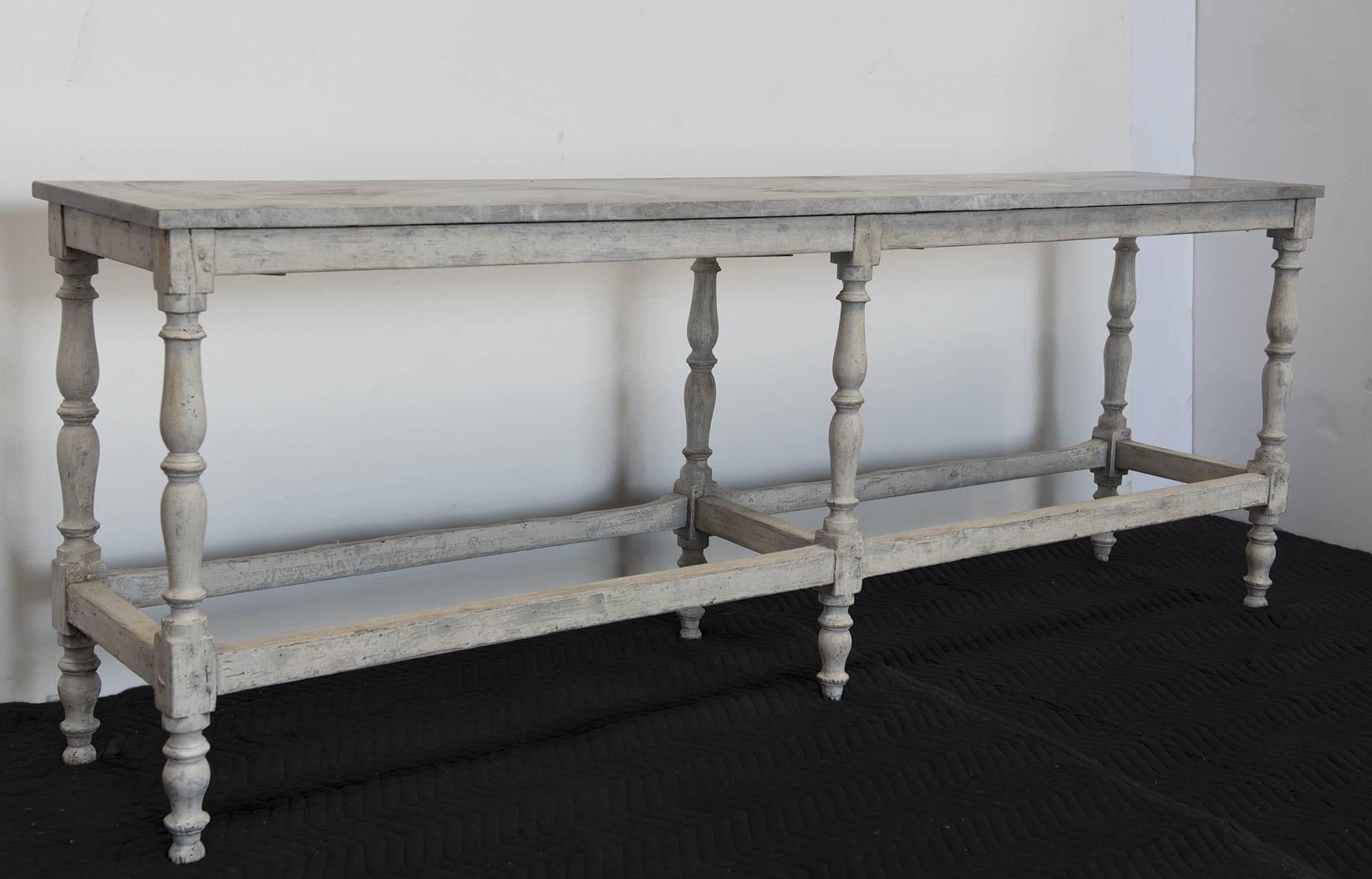 A distressed long wooden table that would work well for a garden console or in a setting inside that works well in a hallway or living room. Sturdy and reliable with a wonderful patina and light-muddled marble top, French, circa 1890.
