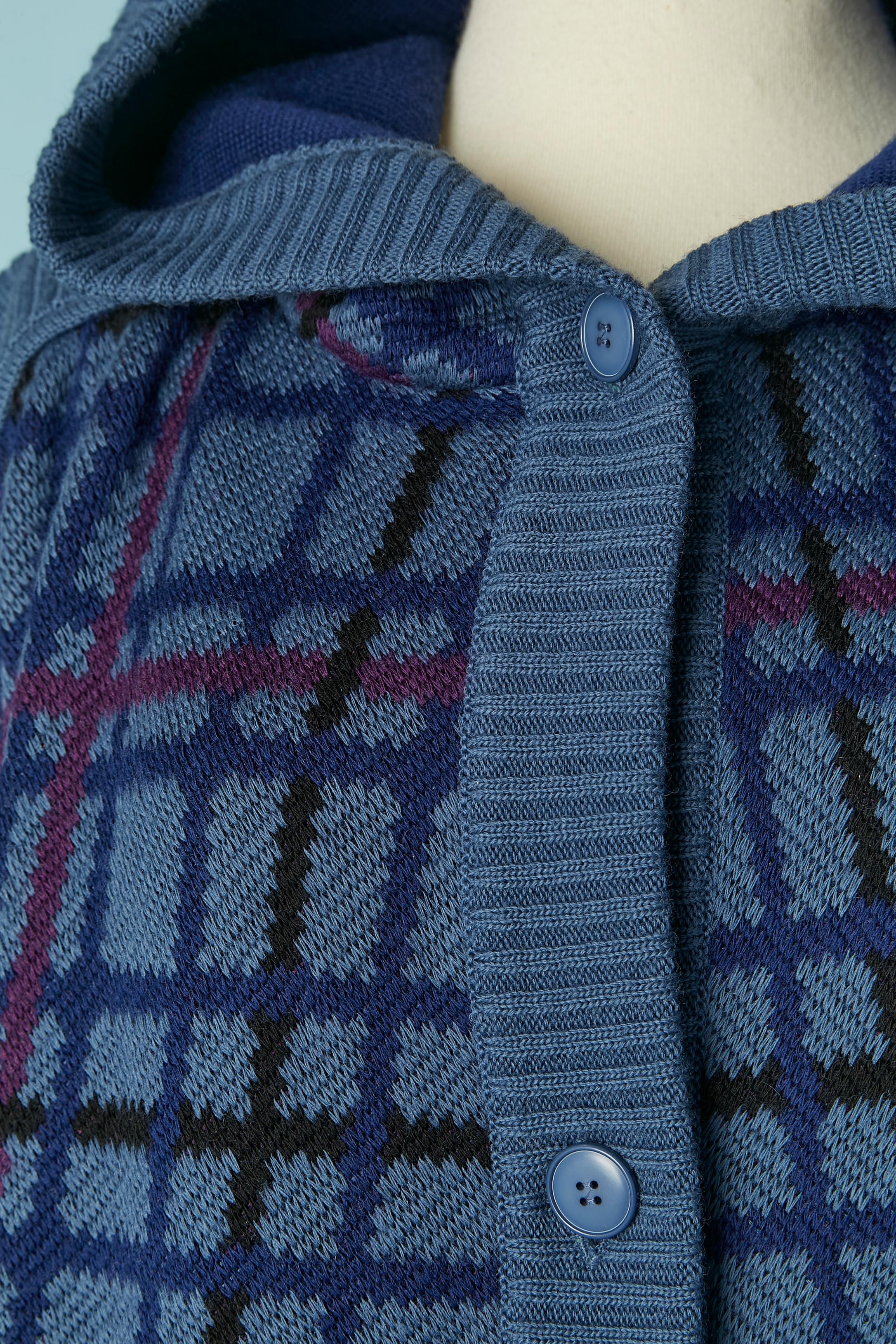 Lange Wollstrickjacke mit Kapuze und Karomuster. Tasche auf beiden Seiten. Knopf- und Knopflochverschluss in der vorderen Mitte. 
GRÖSSE 38 (Fr) M auf dem Etikett, passt aber auch in L 