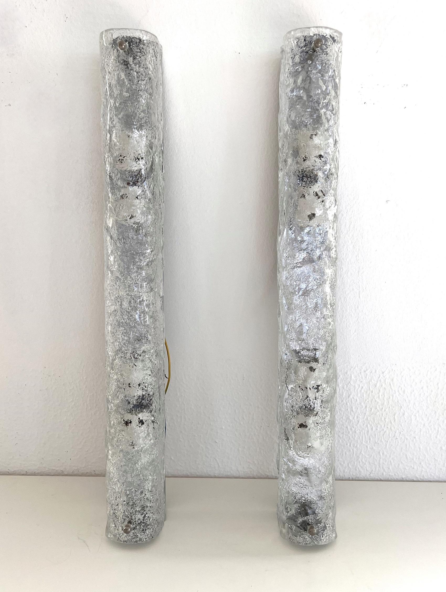 Extra long pair of long tube hand-crafted Murano textured ice glass wall lights on a chromed metal base manufactured by Hillebrand Leuchten, Germany, in the 1970s. 
Each lamp is equipped with ceramic quality bulb holders and takes 4 x E14 candelabra