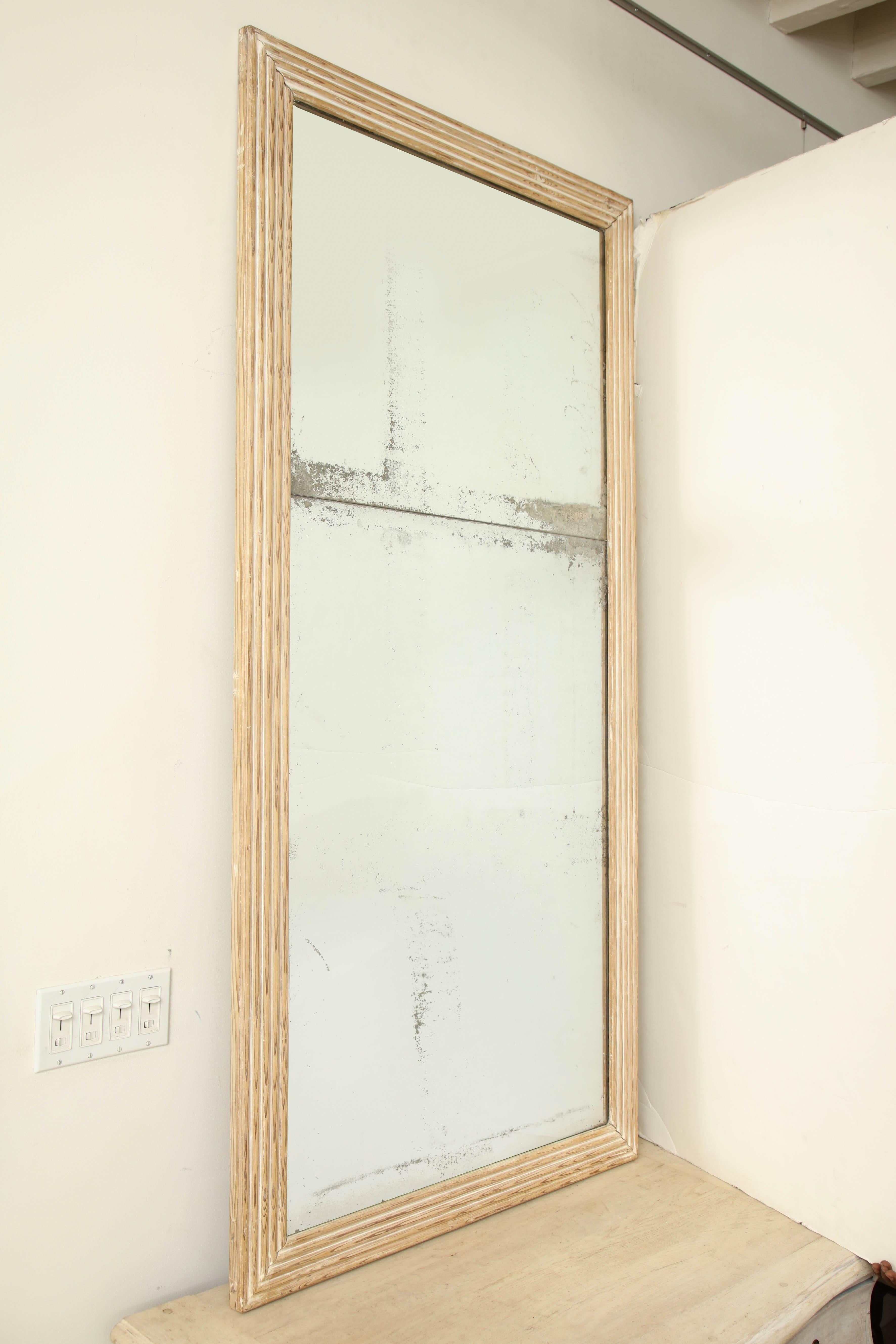 19th century French ribbed and lightly cerused wood mirror with original glass, circa 1830.