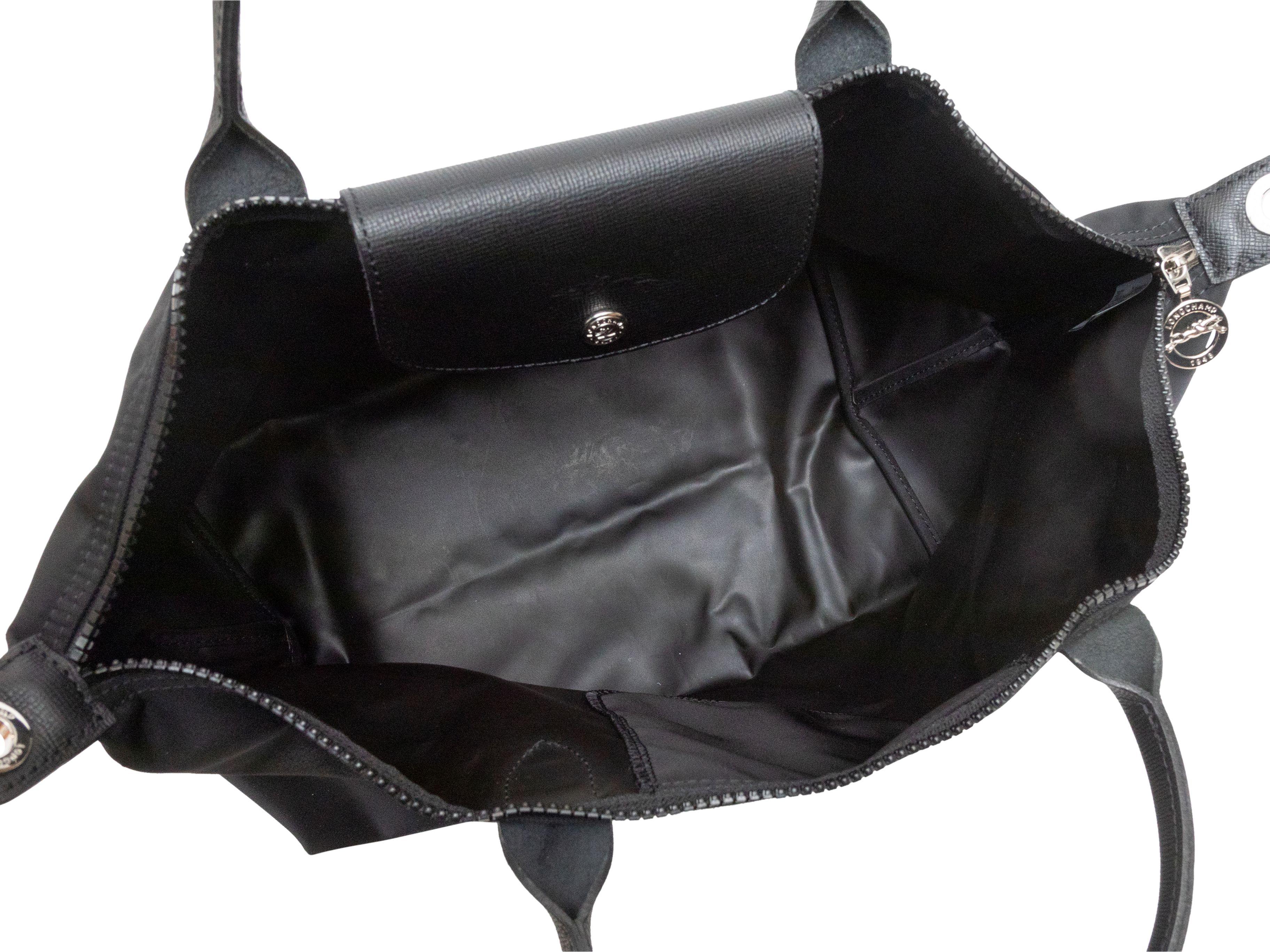 Détails du produit : Longchamp Le Pliage Crossbody Tote Bag noir. Le fourre-tout Le Pliage se compose d'un corps en nylon, d'une bordure en cuir, de deux poignées roulées, d'une bandoulière plate et d'une fermeture à glissière sur le dessus. 10.5