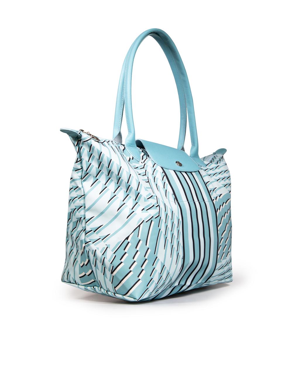 CONDITION is Very good. Hardly any visible wear to bag is evident on this used Longchamp designer resale item.
 
 Details
 Model: Le Pliage
 Blue
 Cloth textile
 Medium tote bag
 Abstract pattern
 Blue leather trim
 2x Rolled top handles
 Flap with