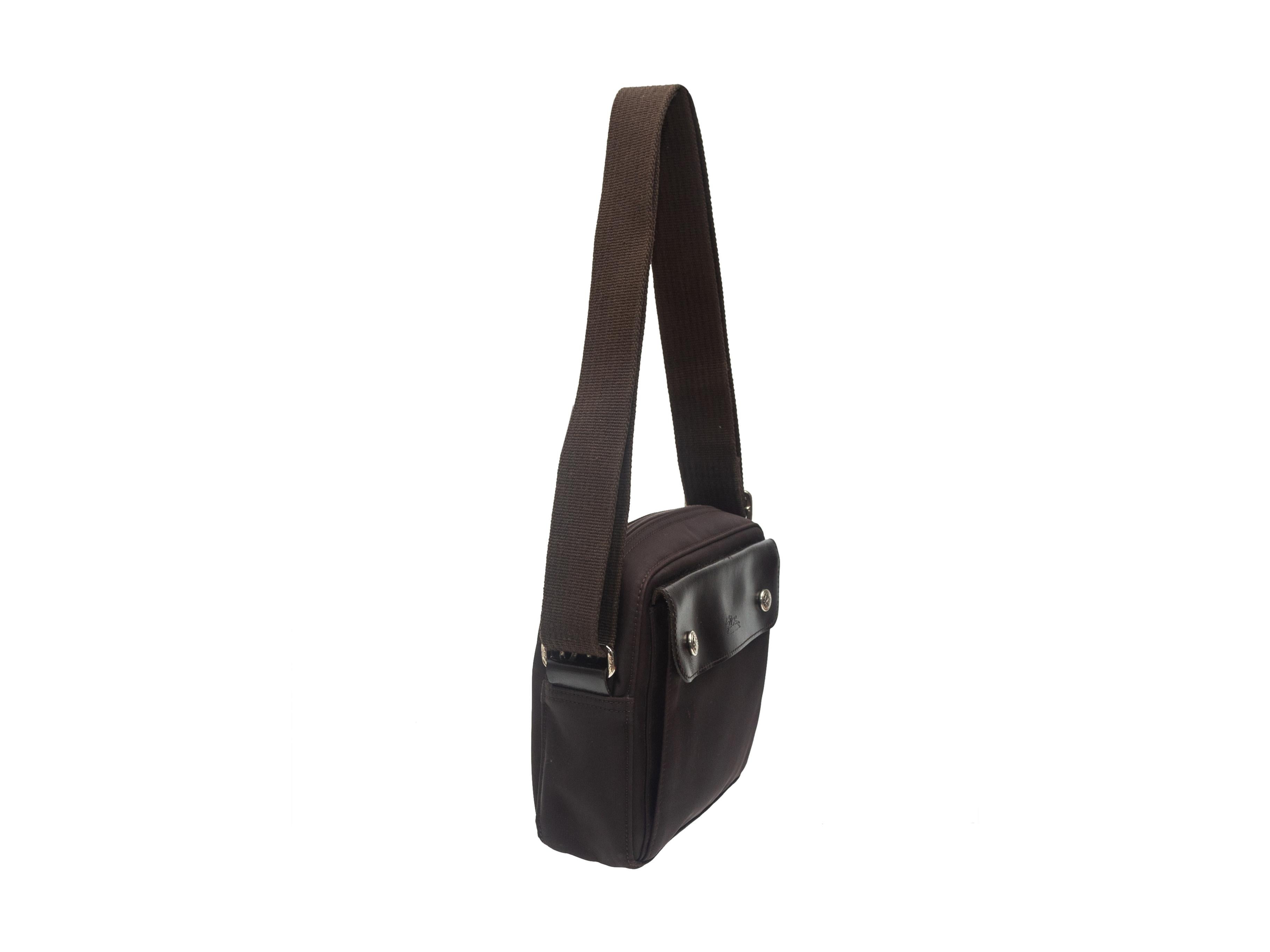 Product details: Brown nylon crossbody bag by Longchamp. Adjustable strap. Flap pocket at exterior front. Zip closure at top. 8